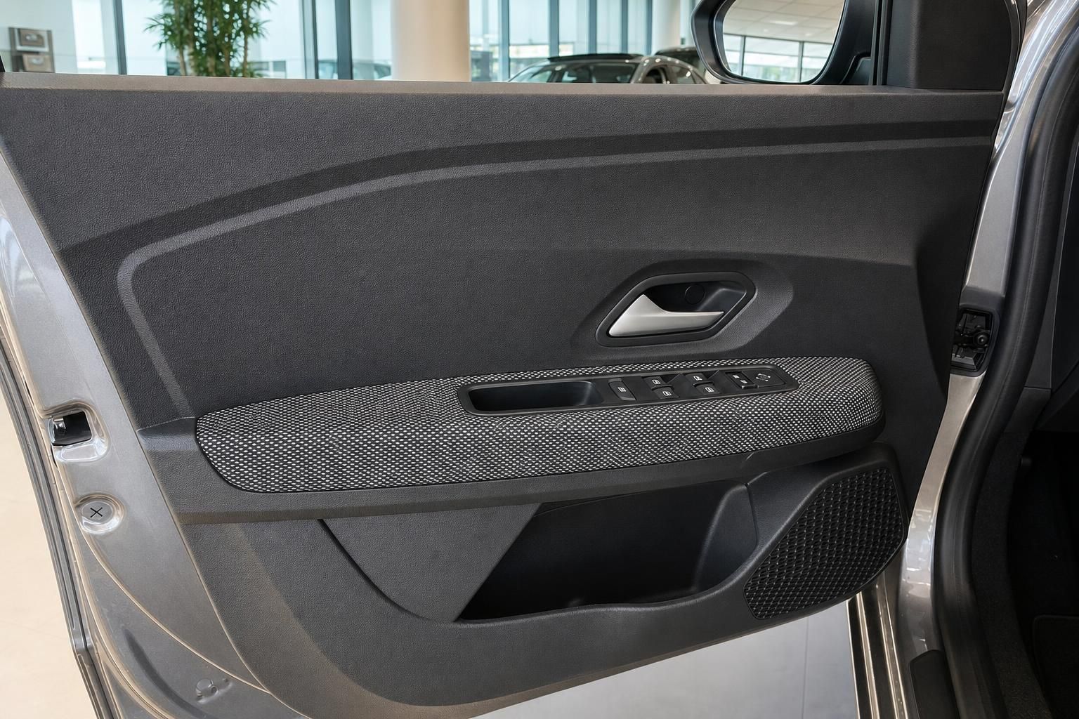 Fahrzeugtür-Innenverkleidung mit Fensterheber-Bedienung und Türgriff in grauem Textil-Design