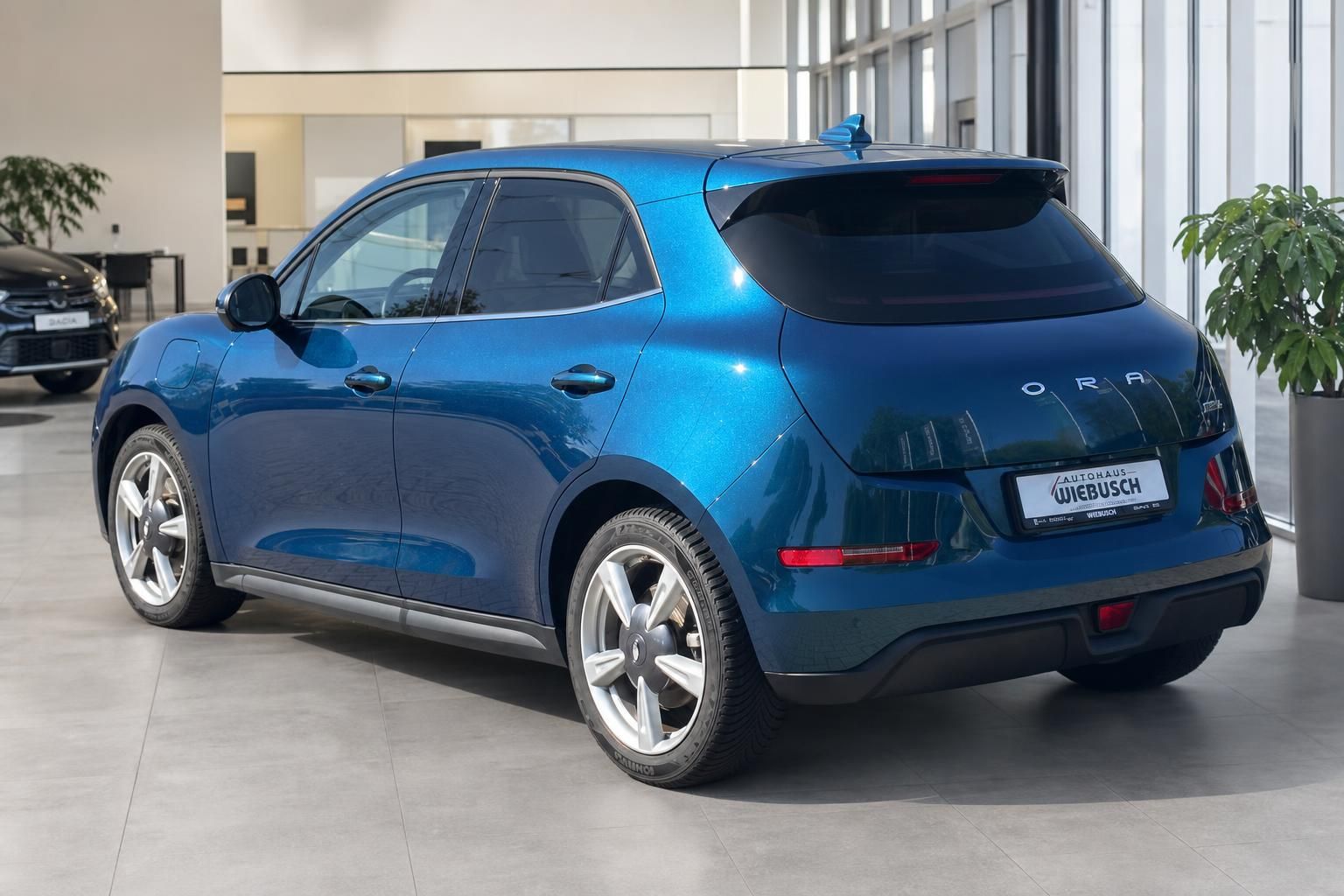 Blauer Ora Funky Cat Elektro-SUV in modernem Autohaus, Seitenansicht mit sportlichen Felgen