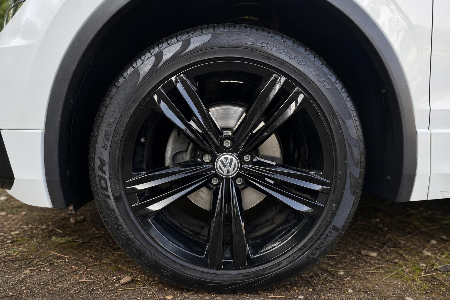 Volkswagen schwarze Leichtmetallfelgen mit VW-Logo und Bereifung Detailaufnahme am weißen Fahrzeug