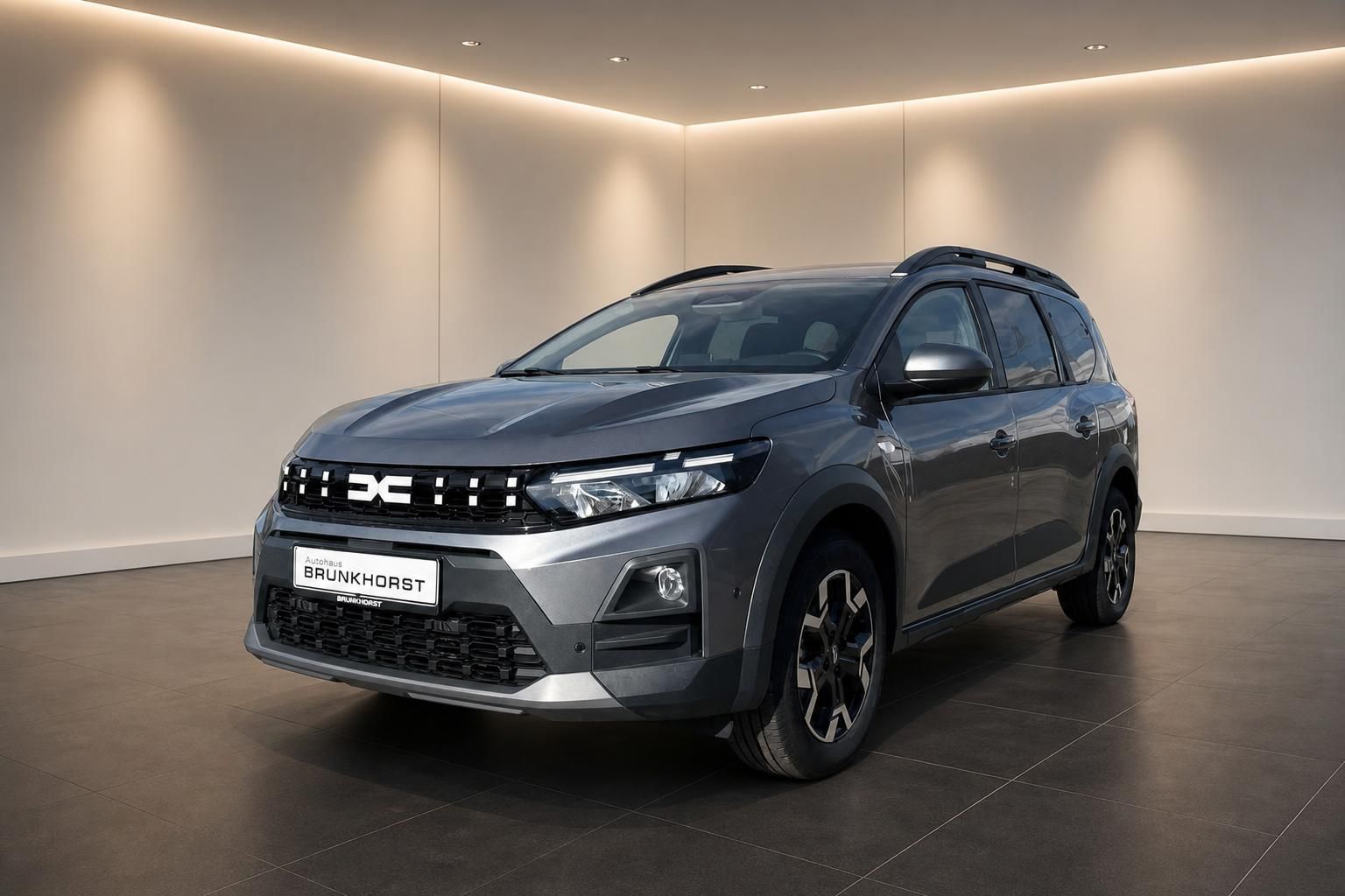Dacia SUV in grauer Metallic-Lackierung, Seitenansicht im modernen Showroom