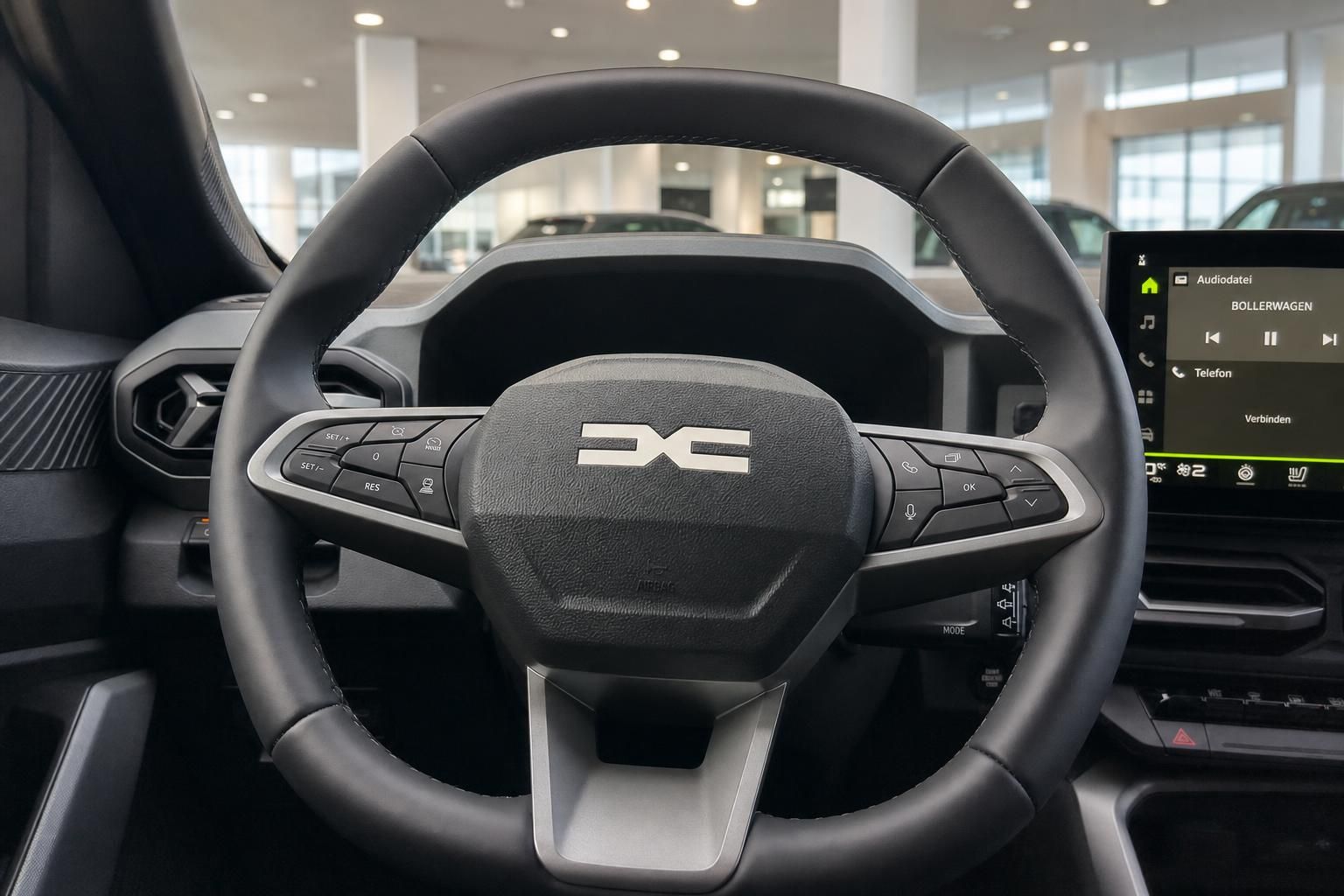 Lenkrad und Cockpit mit Infotainment-Display und Multifunktionstasten