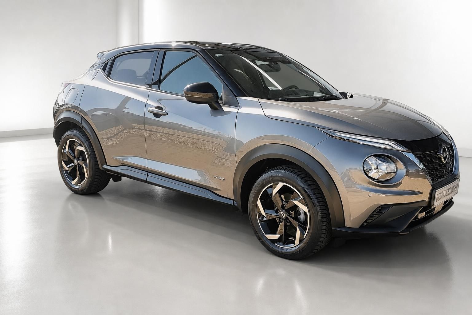 Nissan Juke Hybrid in Grau-Bronze, Frontansicht seitlich im Studio