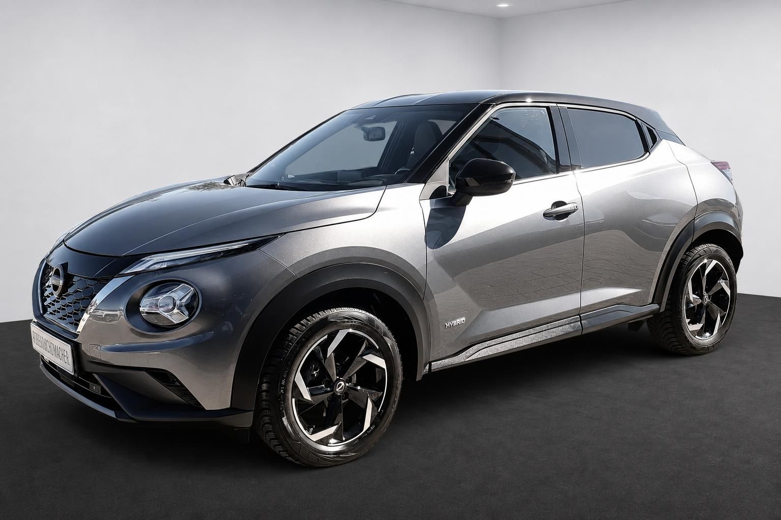 Nissan Juke Hybrid in Grau, Seitenansicht schraeg von vorn
