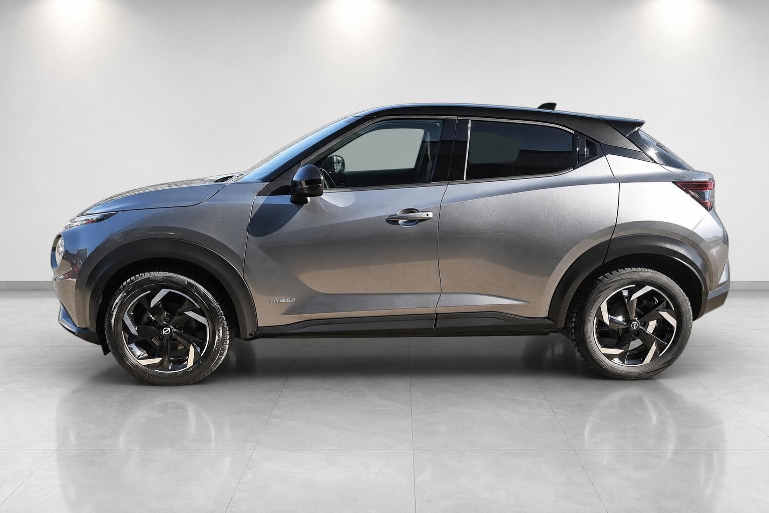 Nissan Juke Hybrid Seitenansicht in Grau-Bronze im Showroom