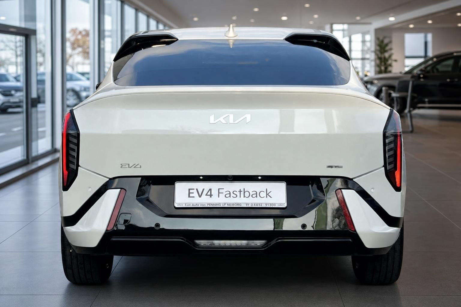 Kia EV4 Fastback weiß, Heckansicht mit Kennzeichen im Autohaus