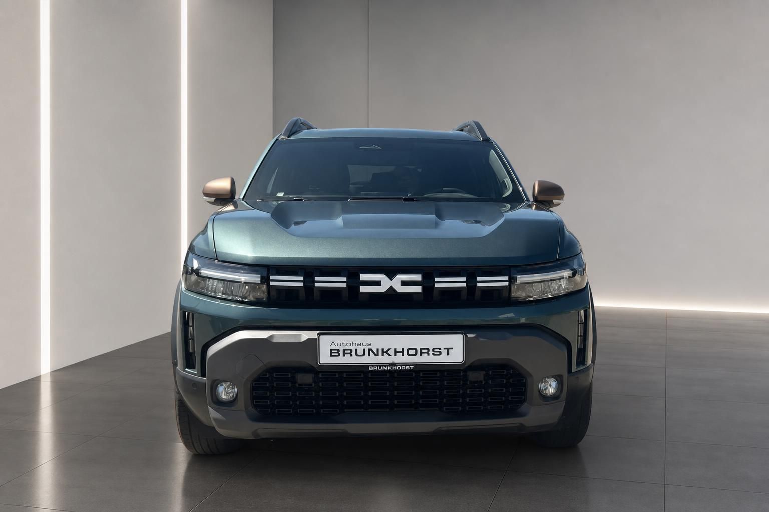 Dacia Duster SUV Frontansicht in grün metallic mit LED-Scheinwerfern im Showroom