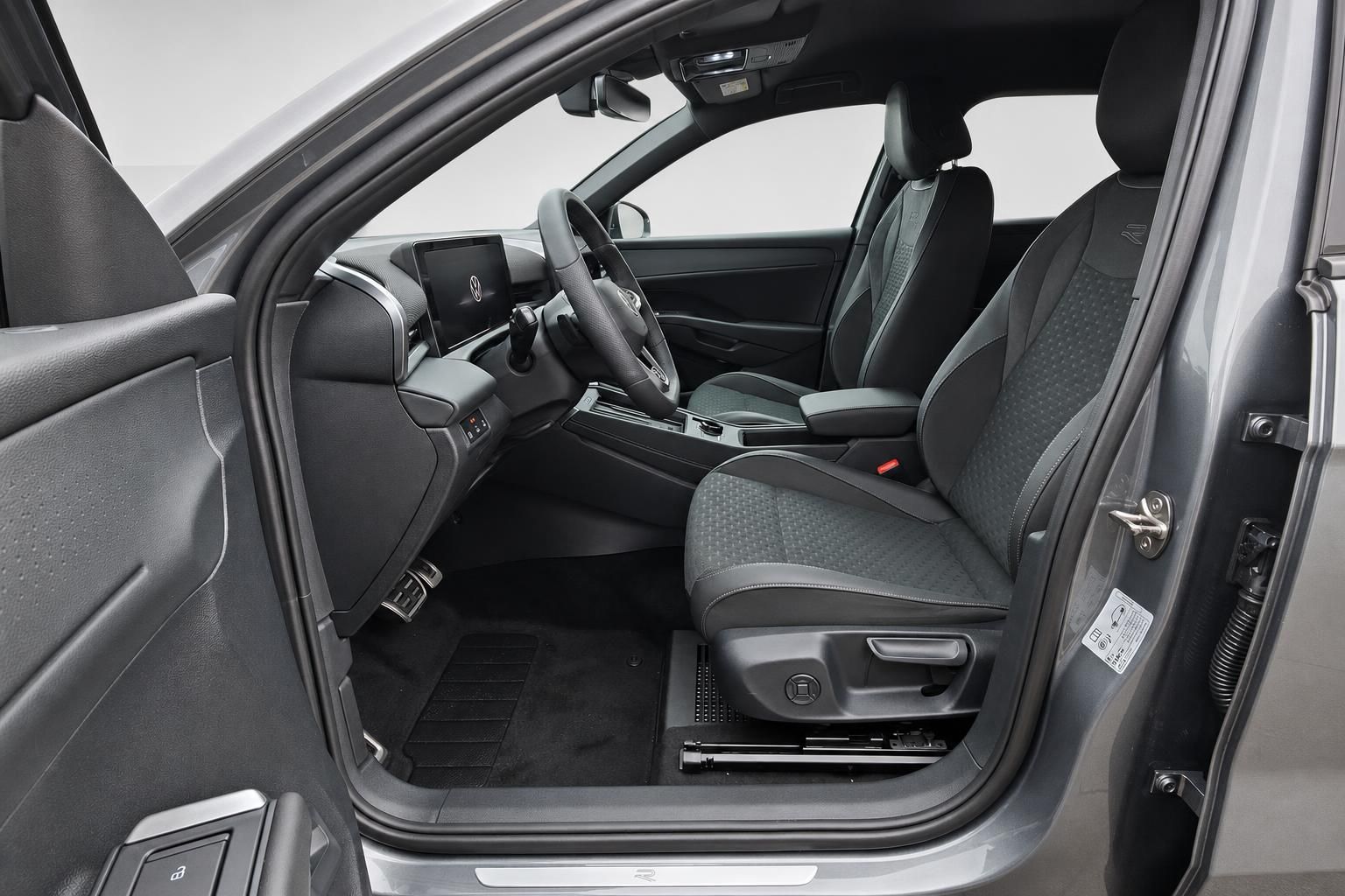 VW Innenraum Blick durch geoeffnete Fahrertuer auf Sitze und Armaturen