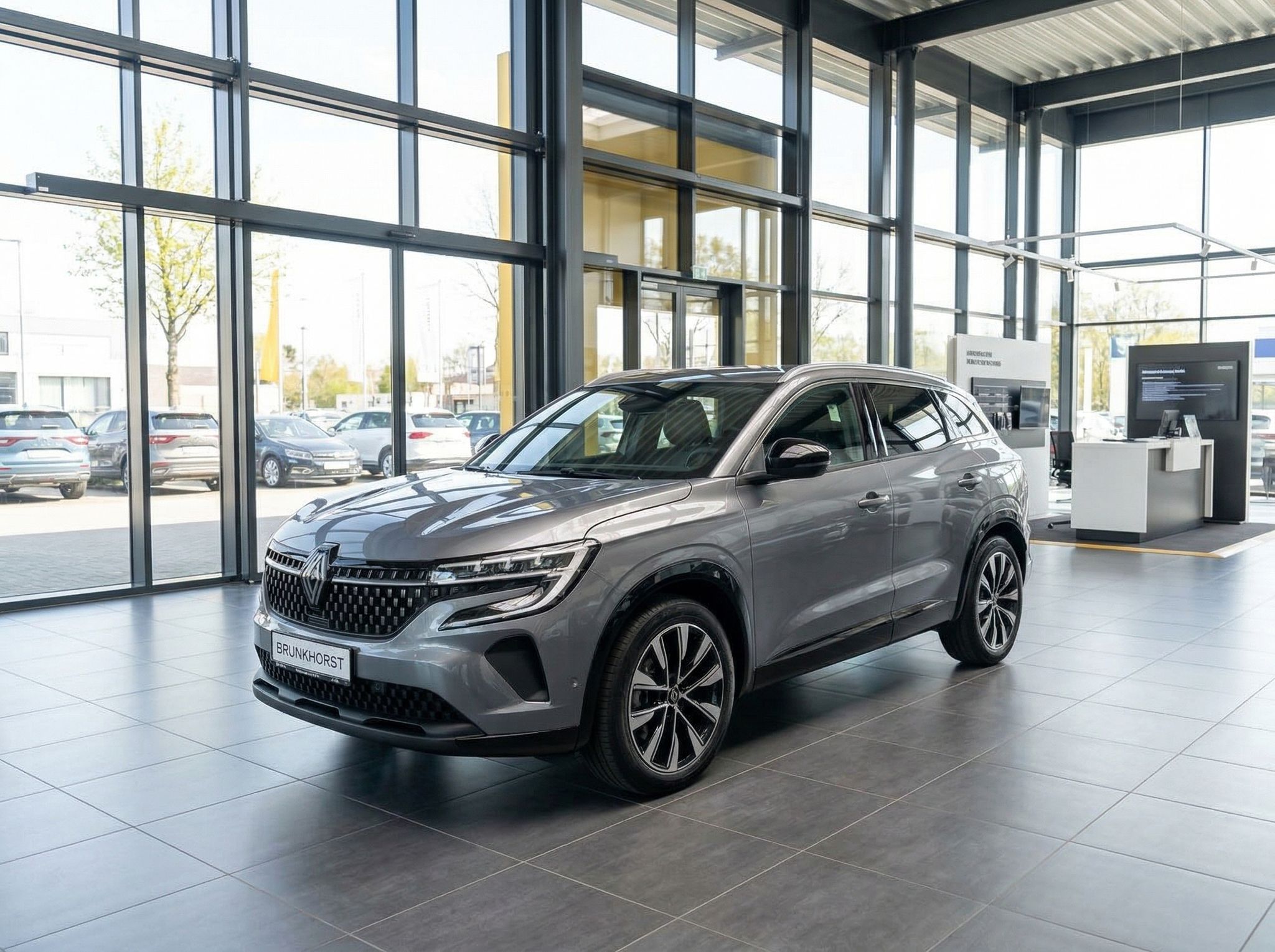 Grauer Renault Austral SUV in modernem Autohaus-Showroom mit großen Glasfenstern