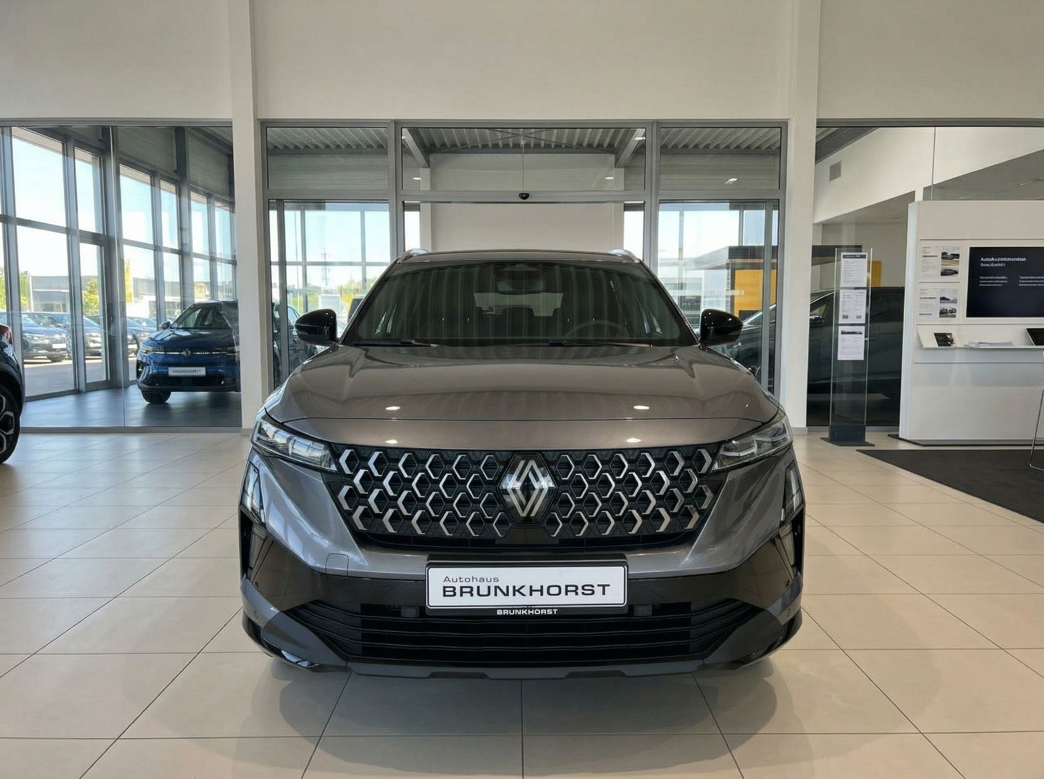 Renault Austral Frontansicht in grau im Autohaus mit charakteristischem Kühlergrill