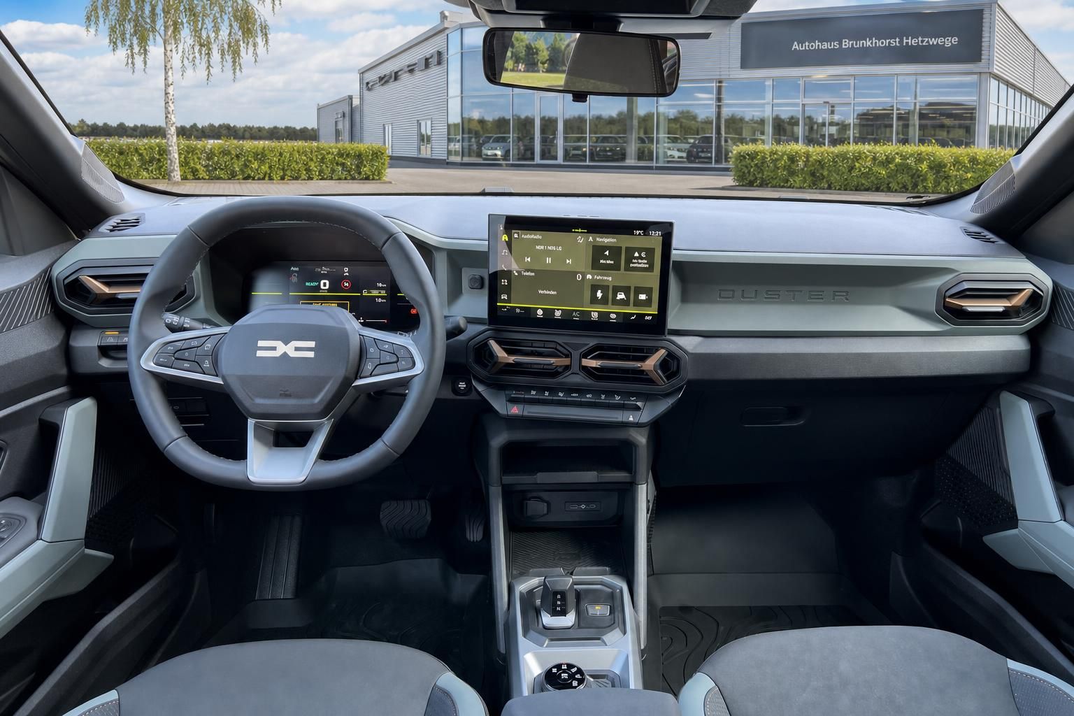 Cockpit-Ansicht mit Lenkrad, Touchscreen-Display und Armaturenbrett eines modernen Fahrzeugs