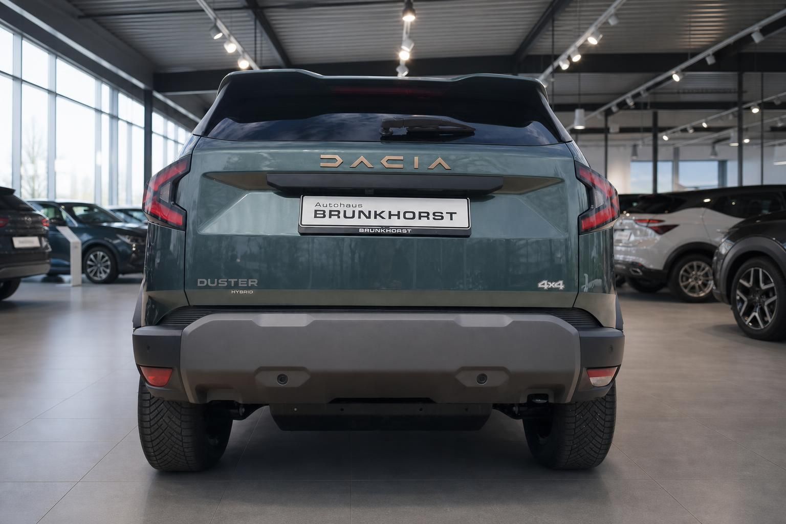 Dacia Duster Hybrid 4x4 Heckansicht in grün-grauer Metallic-Lackierung im Autohaus