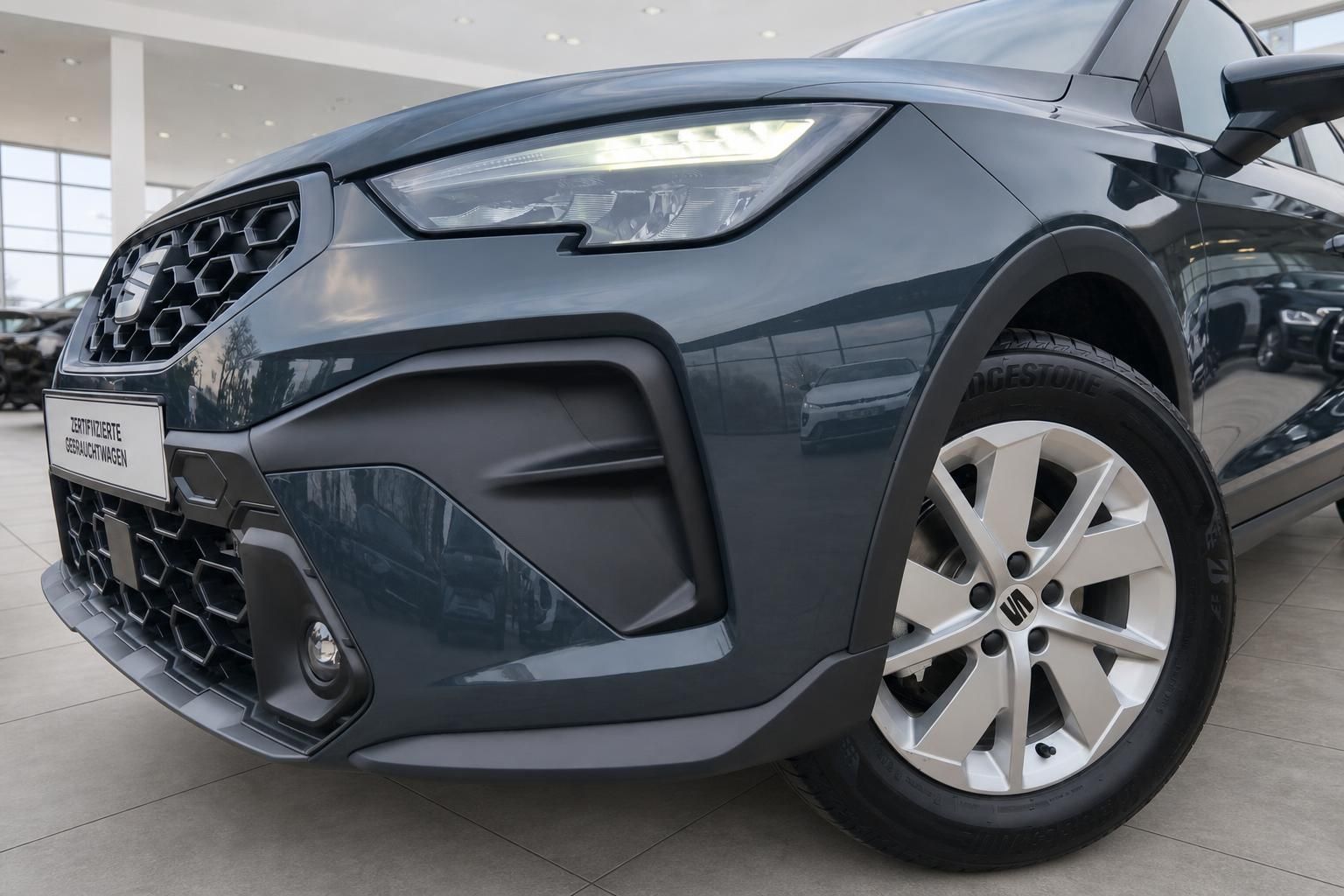 SEAT Arona vorne rechts Detail Scheinwerfer und Felge im Autohaus