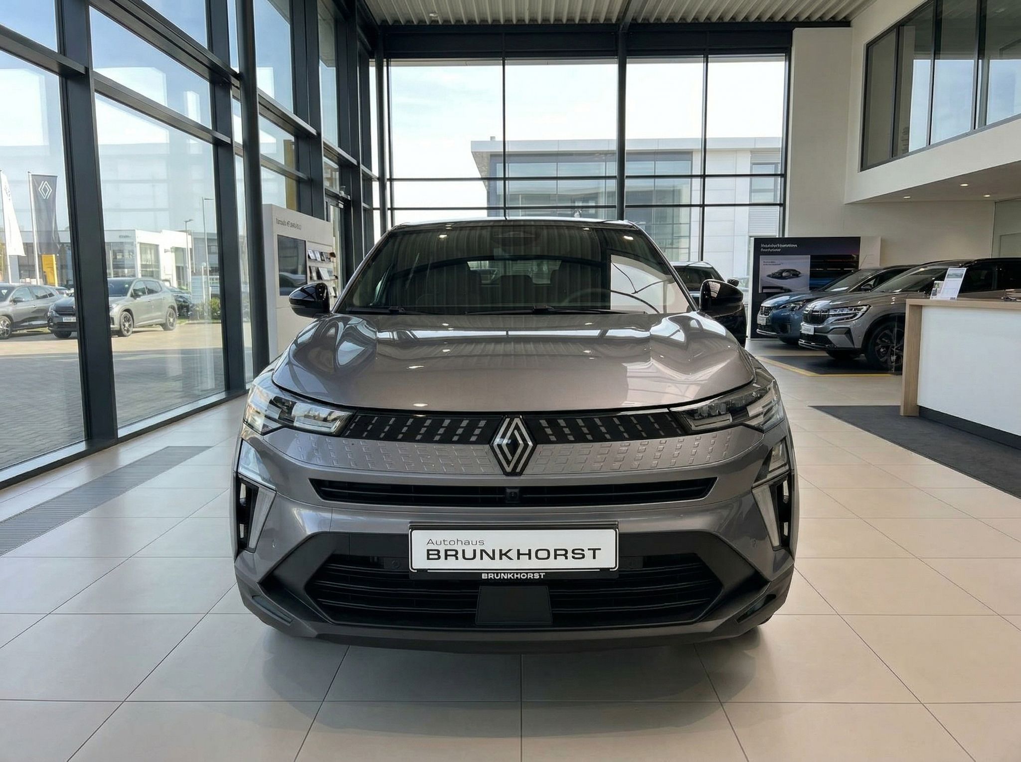 Renault Captur Frontansicht grau metallic mit charakteristischem Kühlergrill im Showroom