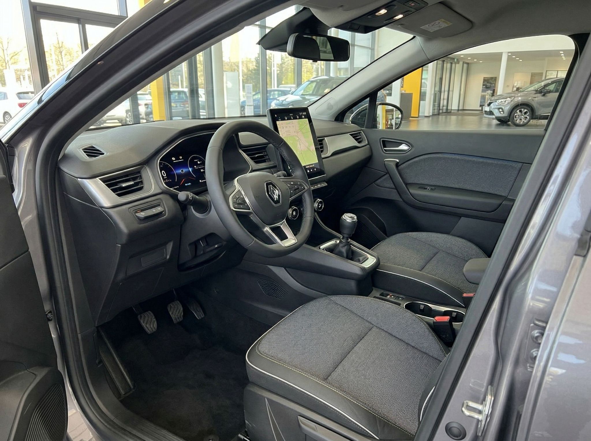 Renault Captur Innenraum mit modernem Cockpit, Touchscreen und schwarzer Stoffausstattung