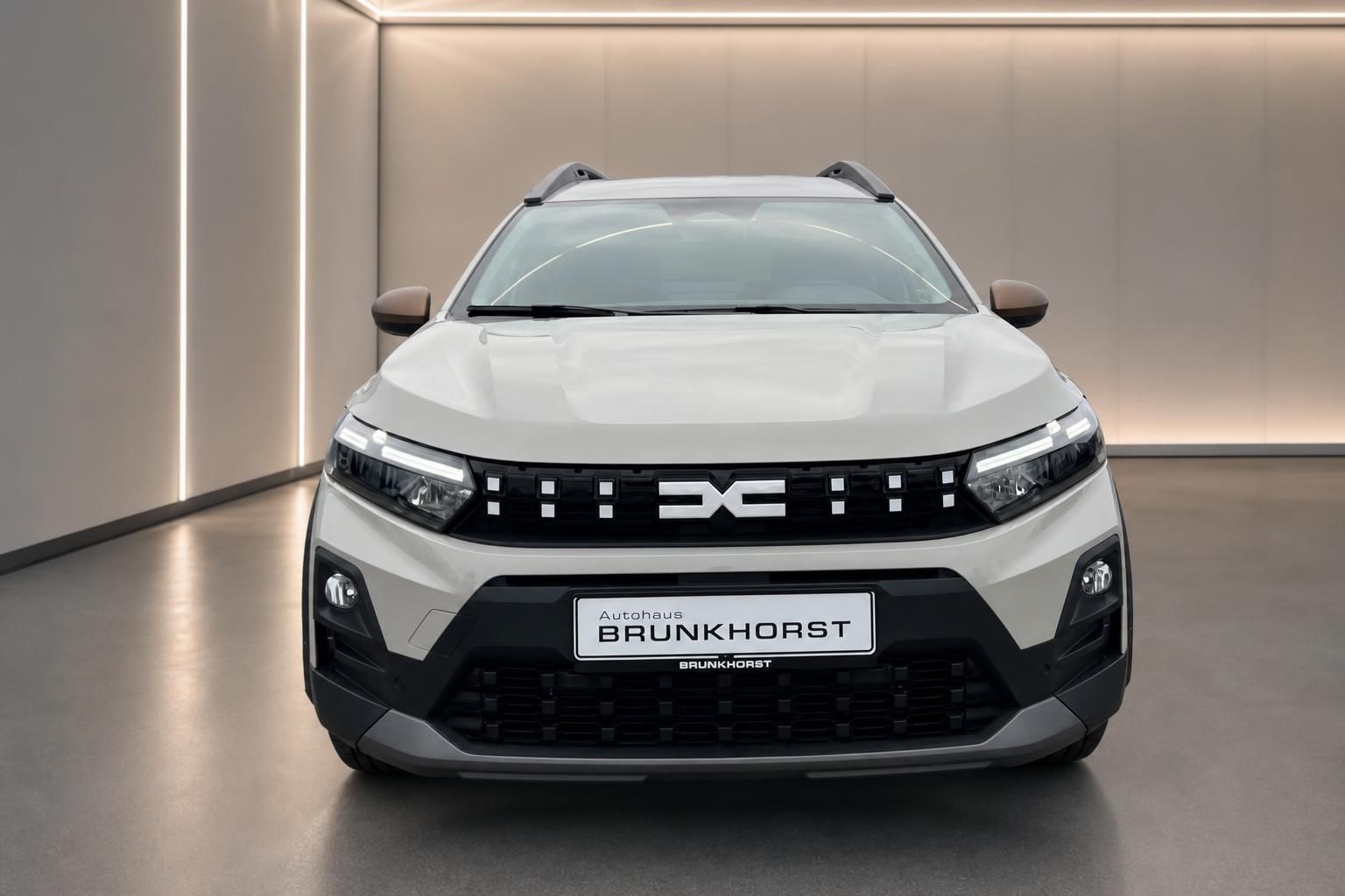 Weißer SUV Frontansicht mit markanter Kühlergrill-Optik im modernen Autohaus-Showroom