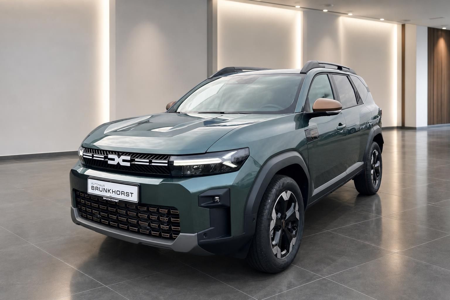 Grüner Dacia Bigster SUV in modernem Autohaus-Showroom - Frontansicht