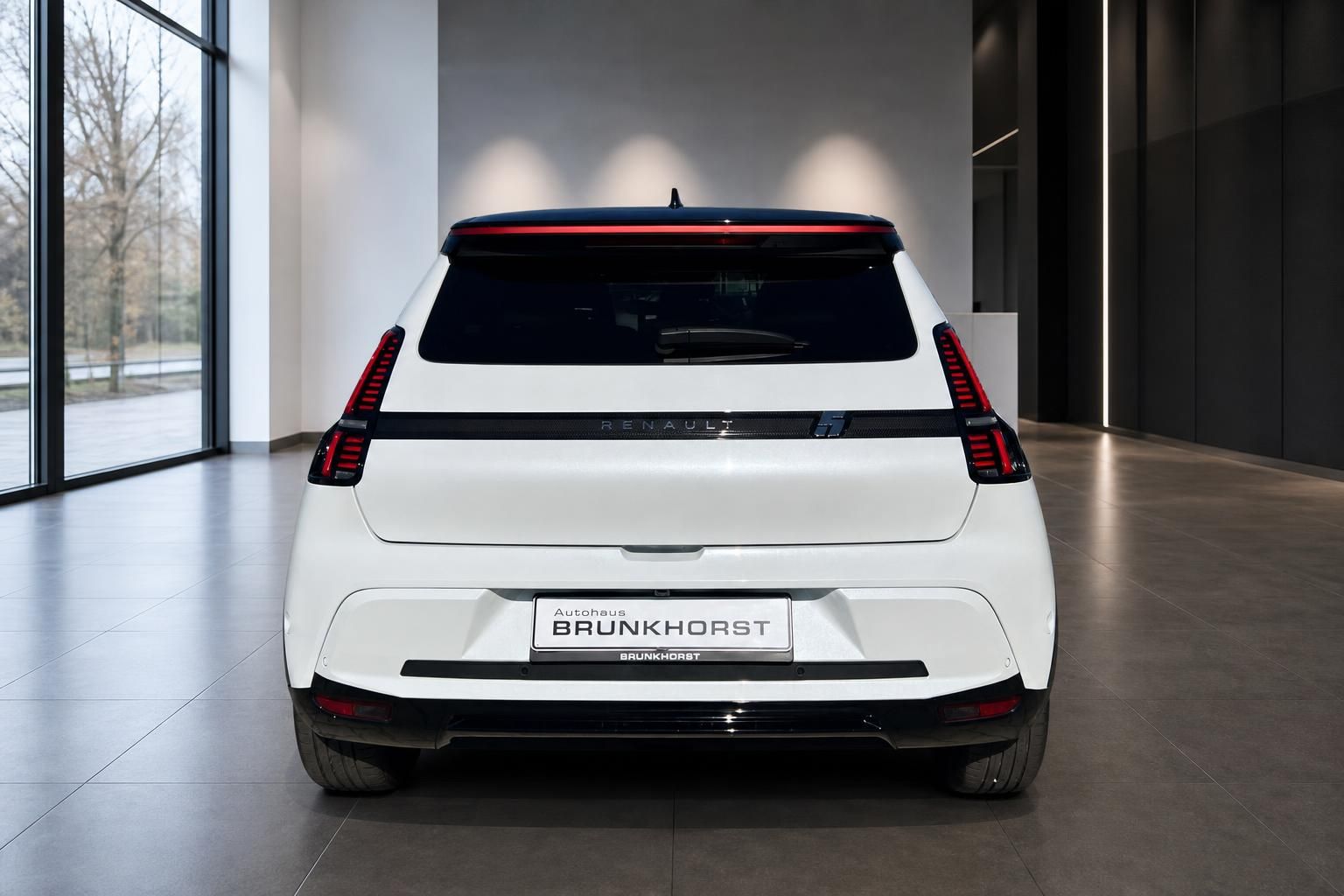 Renault 5 in Weiß, Heckansicht mit LED-Leuchtenband im Autohaus