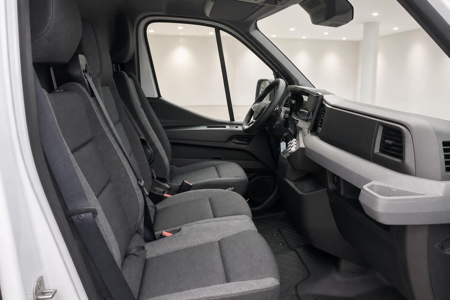 Innenraum eines Transporters mit grauen Stoffsitzen und Cockpit