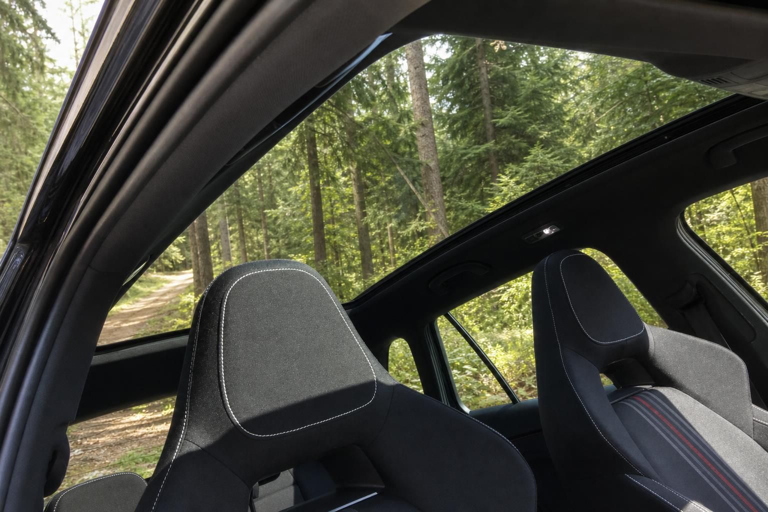 Fahrzeug Innenraum mit Panorama-Schiebedach und Sportsitzen in Waldumgebung