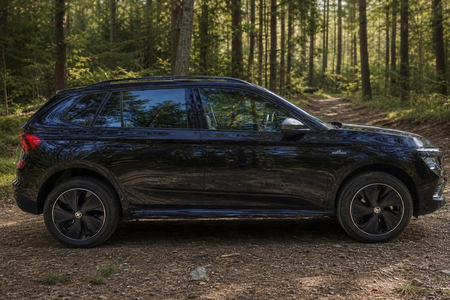 Schwarzer Skoda Kamiq SUV Seitenansicht im Wald - Gebrauchtwagen bei Ernst-Auto