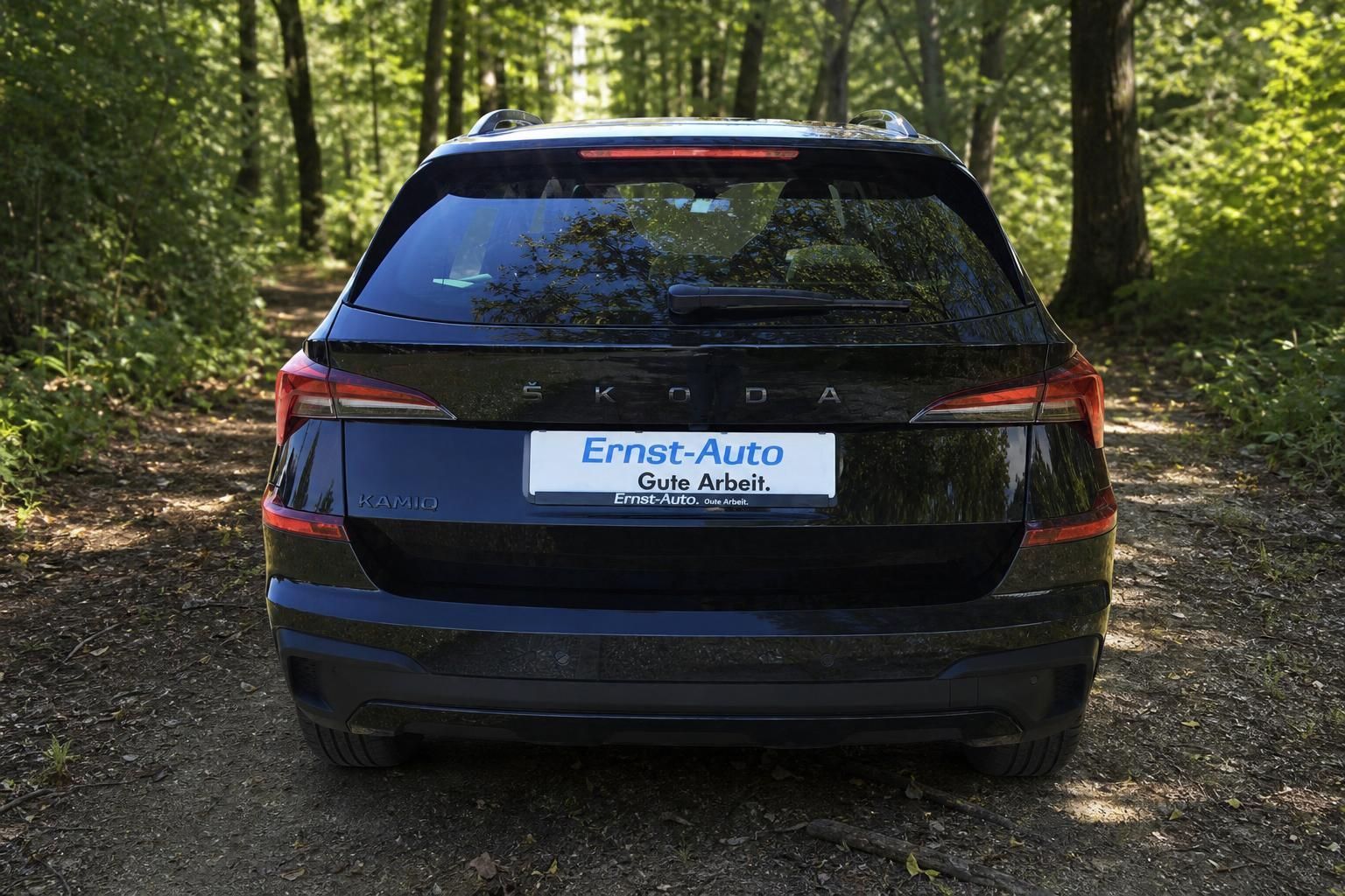 Skoda Kamiq Heckansicht schwarz mit Händlerkennzeichen Ernst-Auto im Waldweg