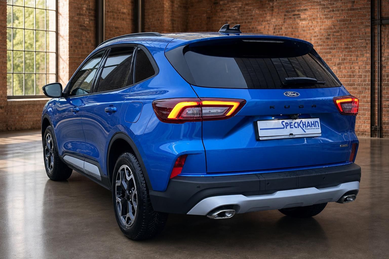 Ford Kuga Hybrid blau Heck-Seitenansicht vor Backsteinwand