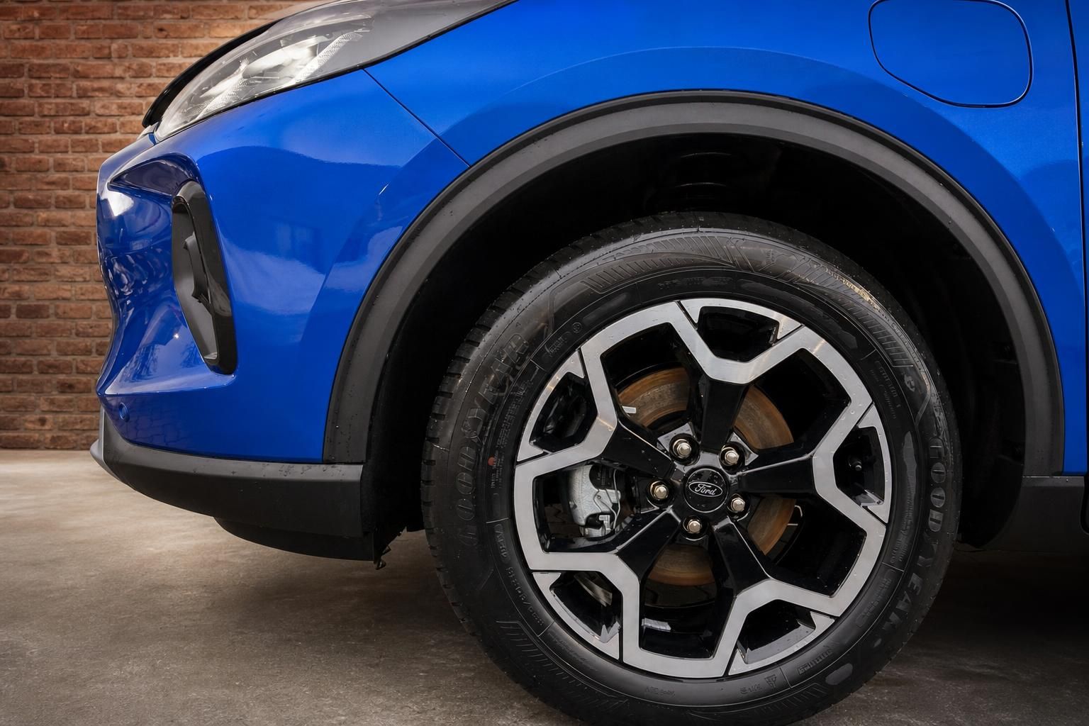 Detailansicht Leichtmetallfelge und Frontstoßstange des blauen Ford SUV