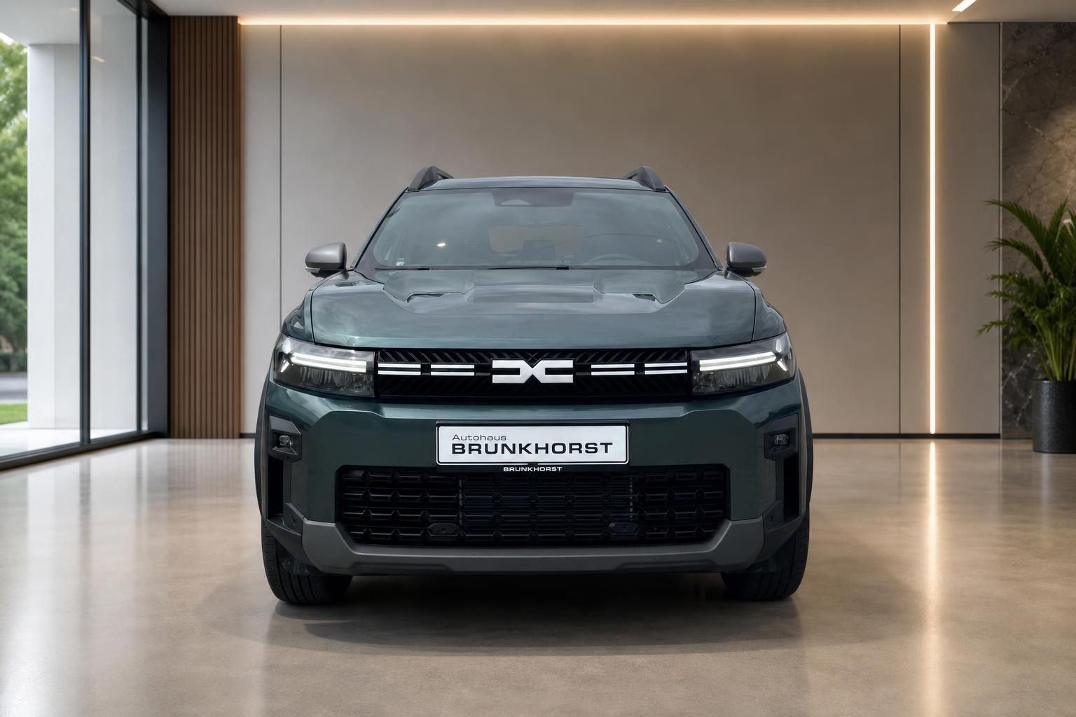 Dacia SUV Frontansicht grün metallic mit LED-Scheinwerfern im Showroom