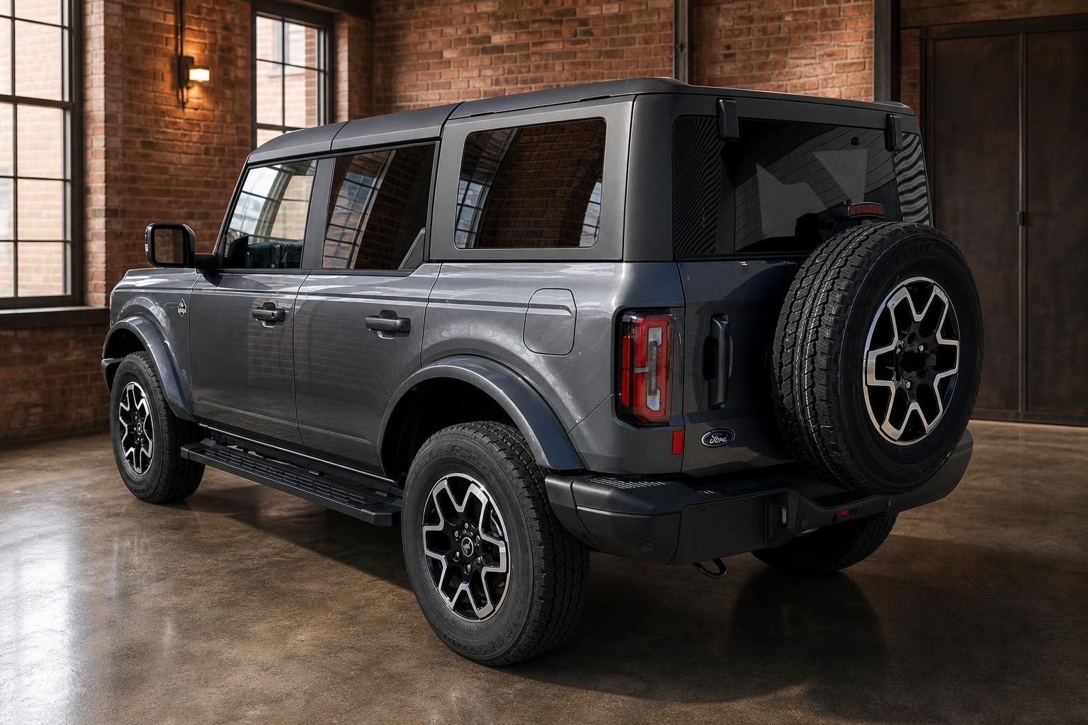 Ford Bronco SUV grau Heckansicht schräg mit Reserverad und Leichtmetallfelgen im Industrieloft