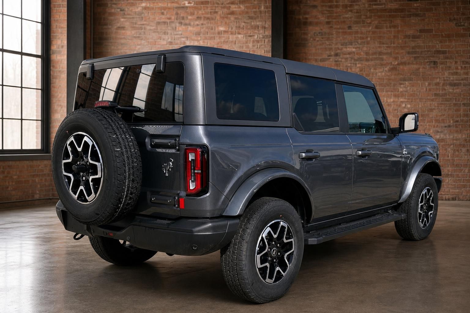 Ford Bronco SUV grau schräge Heckansicht mit Reserverad und offenem Heckfenster im Studio
