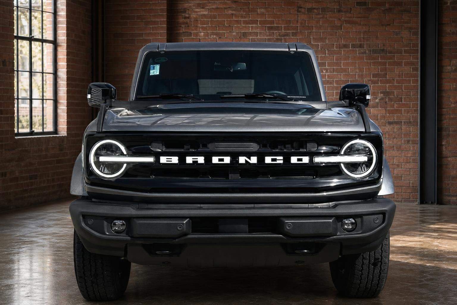Ford Bronco SUV Frontansicht in Grau mit Rundscheinwerfern und Bronco-Schriftzug im Grill