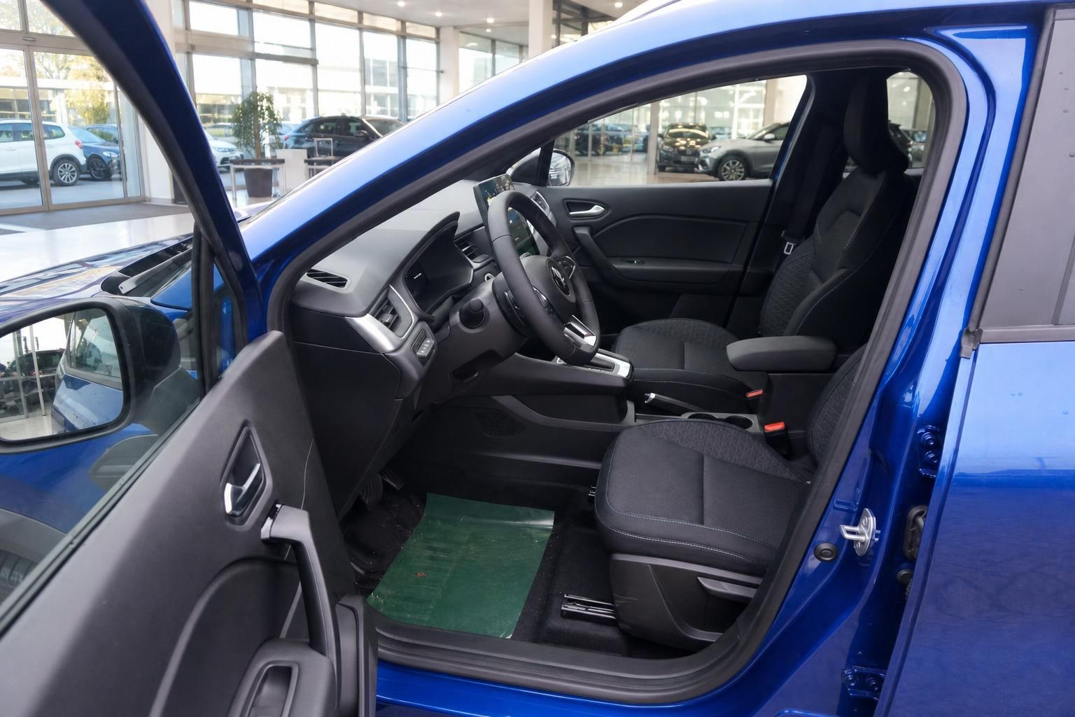 Fahrersitz und Cockpit eines blauen Fahrzeugs im Autohaus-Showroom