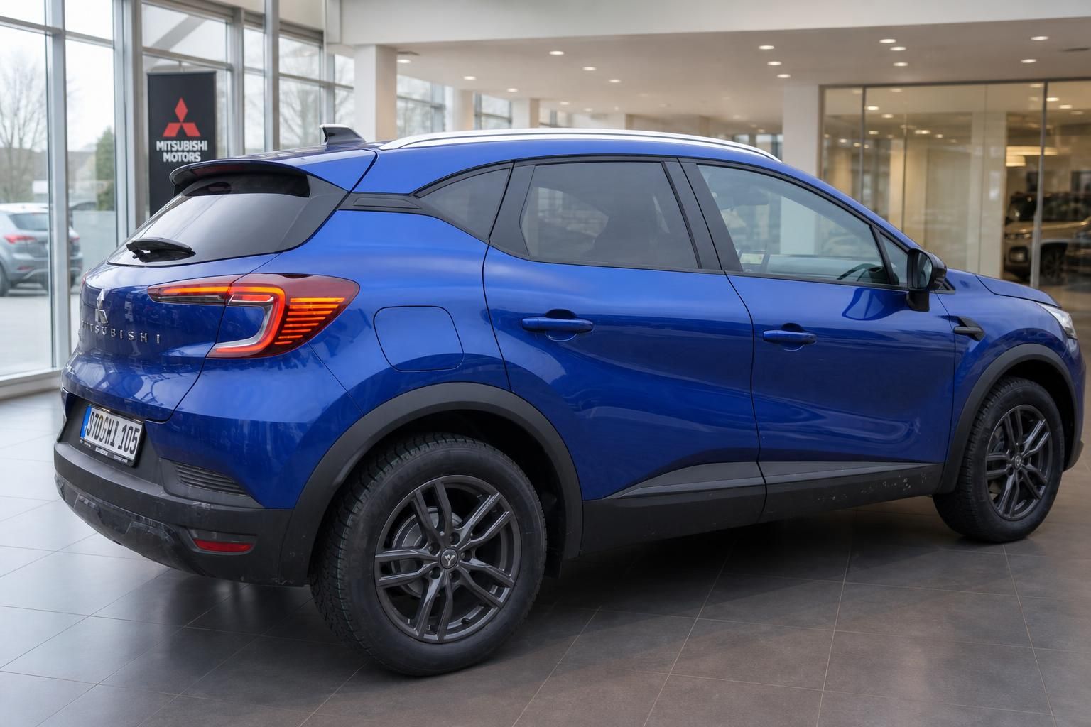 Blauer Mitsubishi SUV Heckansicht schräg im Autohaus Showroom mit LED-Rückleuchten