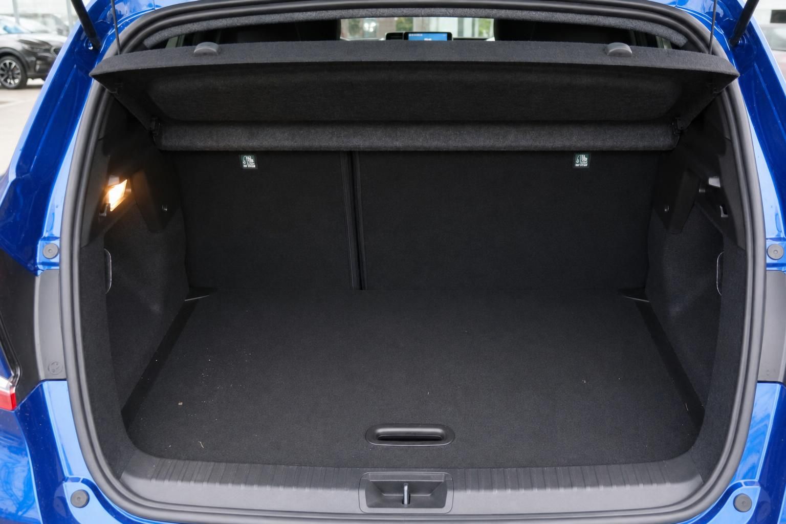 Kofferraum eines blauen Fahrzeugs mit schwarzer Verkleidung und Ladeboden