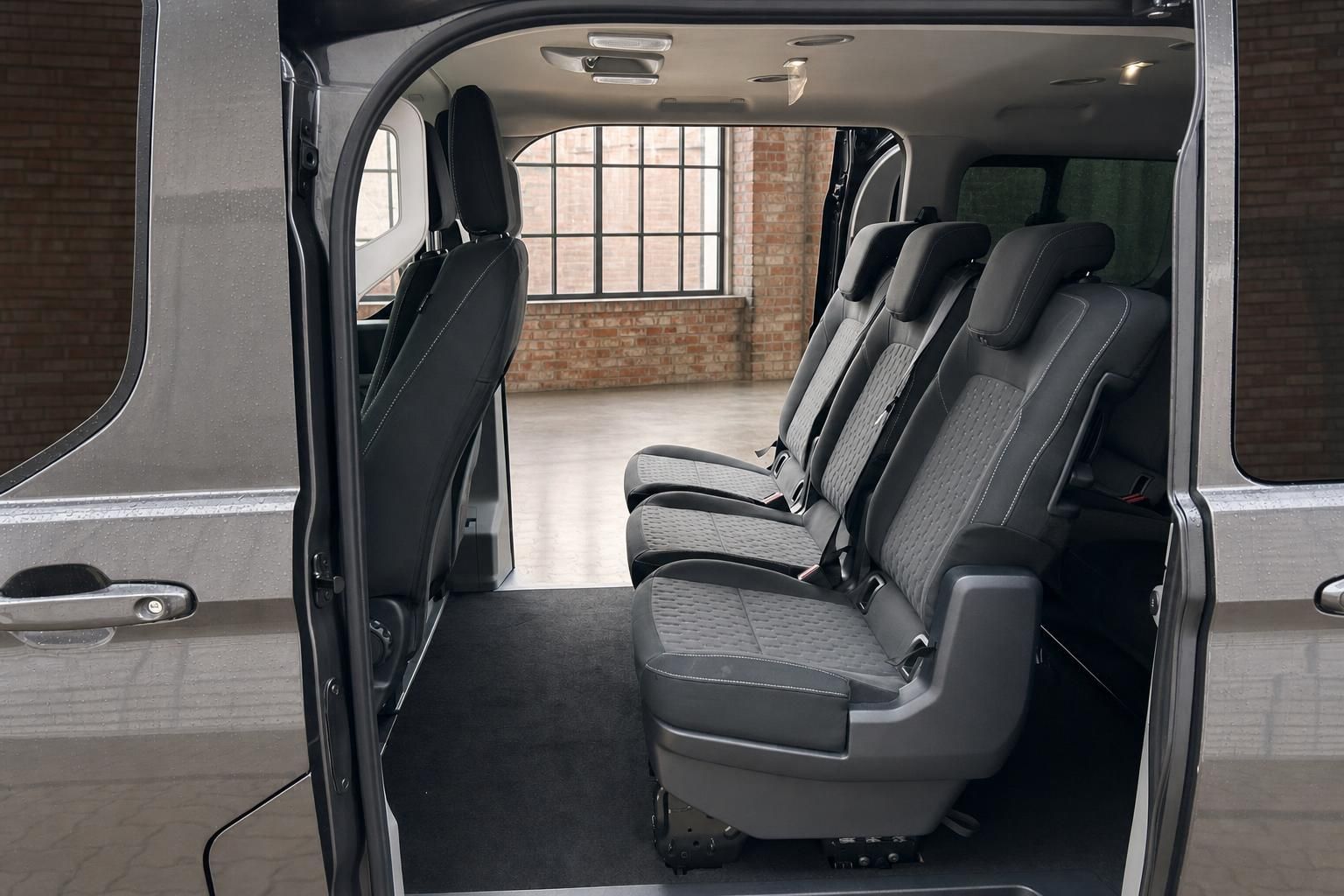 Ford Transit Custom Innenraum – geöffnete Schiebetür mit Blick auf graue Rücksitzbank