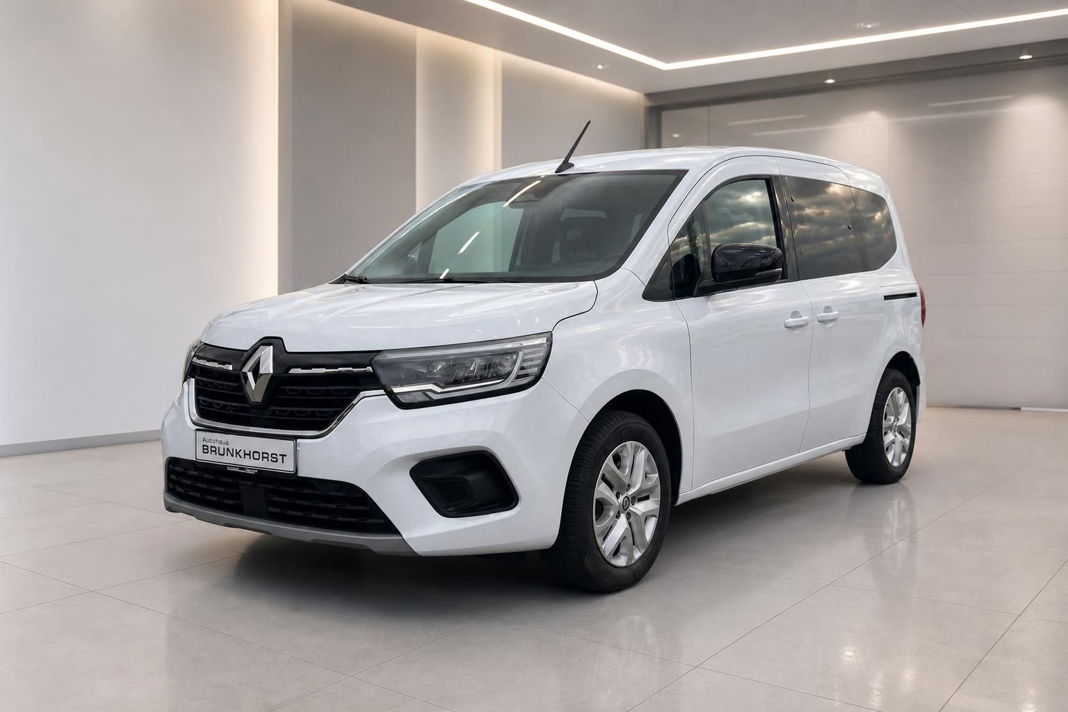 Renault Kangoo weiss Seitenansicht mit Alufelgen im eleganten Autohaus Showroom