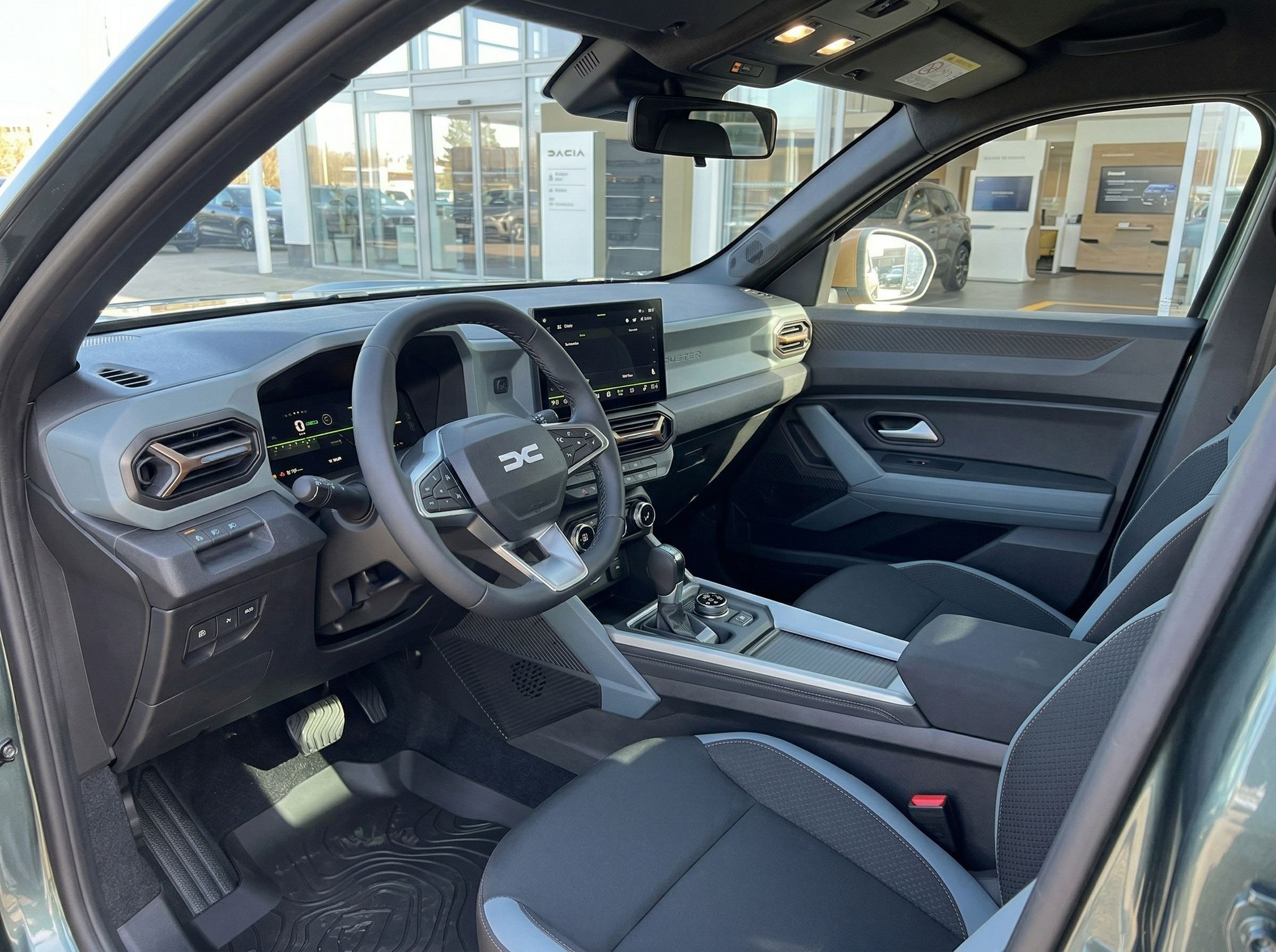 Dacia Innenraum mit schwarzer Ausstattung, Lenkrad, Touchscreen und modernem Cockpit-Design