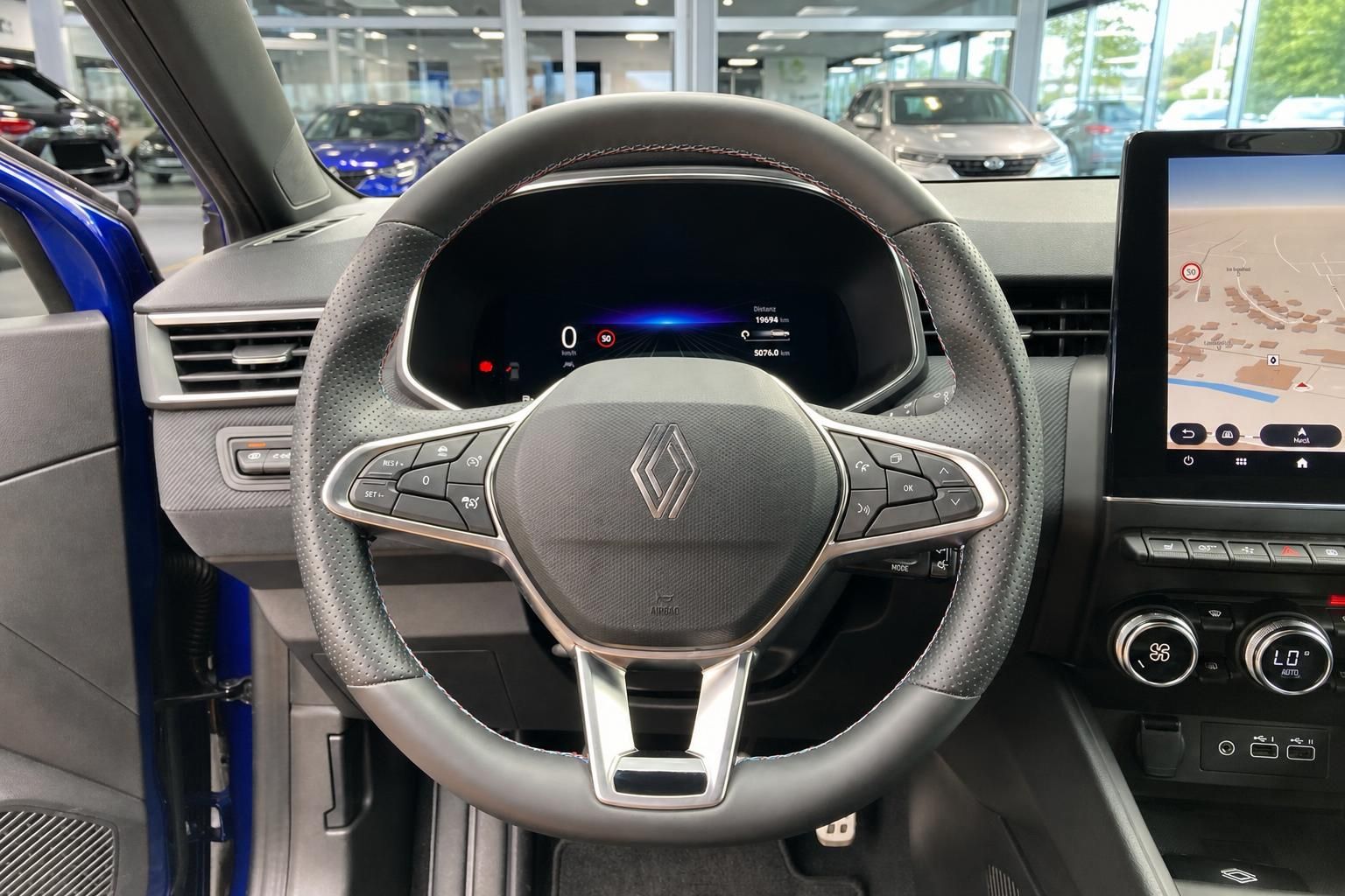 Lederlenkrad mit Multifunktionstasten und Renault-Logo im Fahrzeuginnenraum