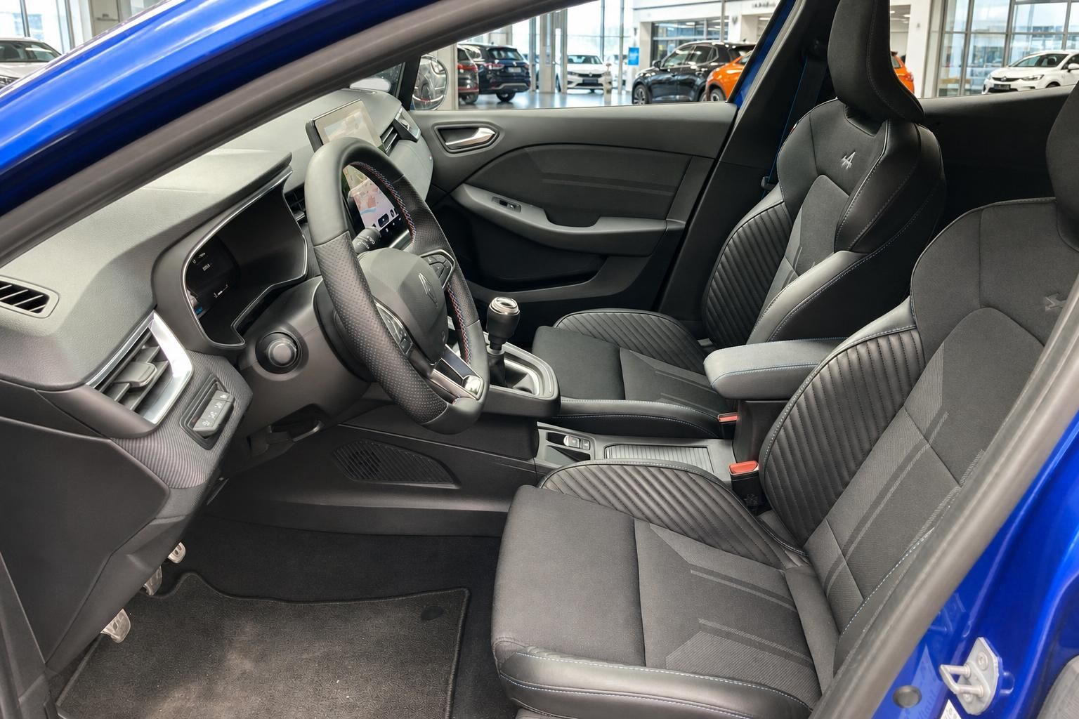Vordersitze und Cockpit eines blauen Renault mit Sportsitzen und Lenkrad