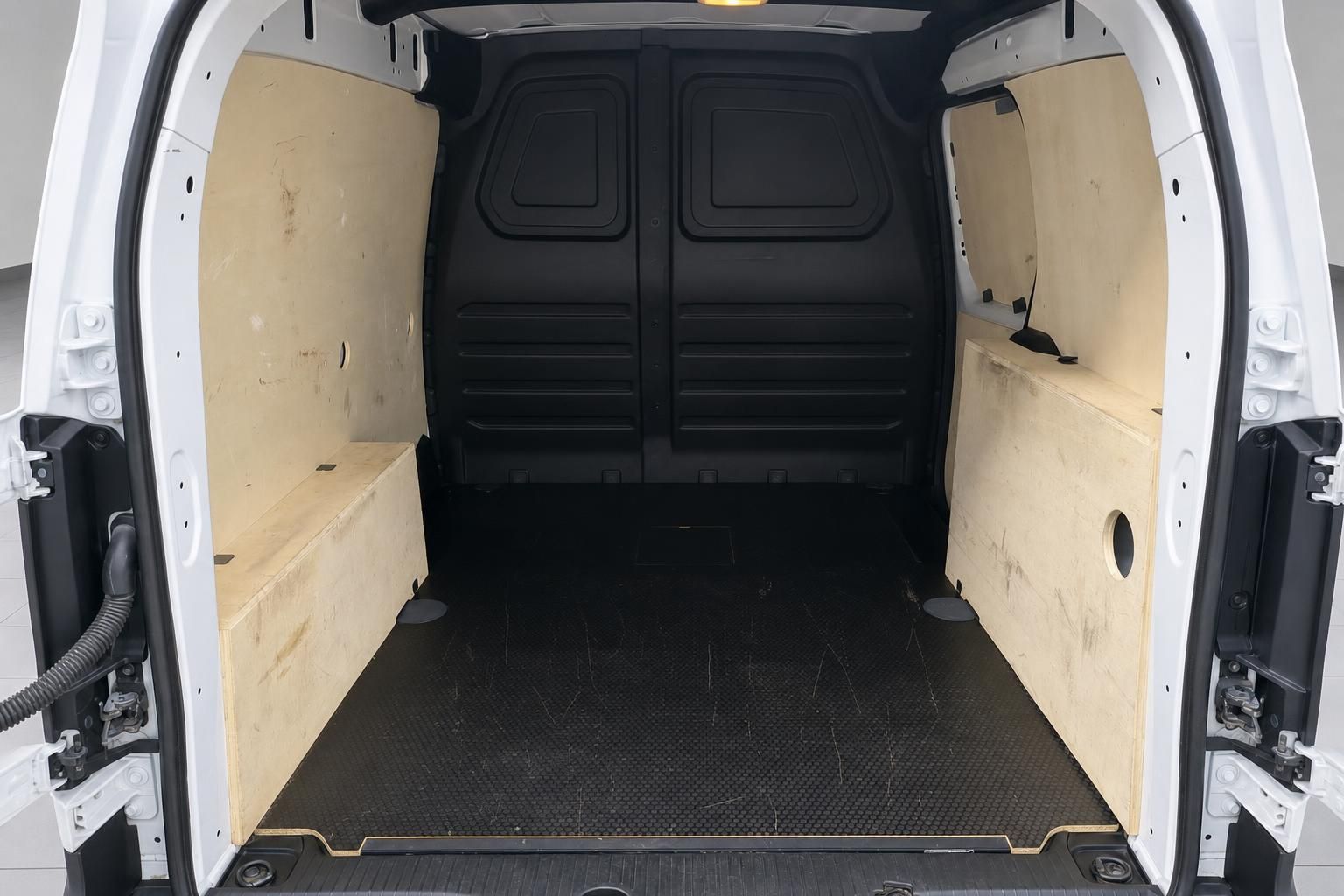 Laderaum eines weißen Transporters mit Holzverkleidung und schwarzem Gummiboden