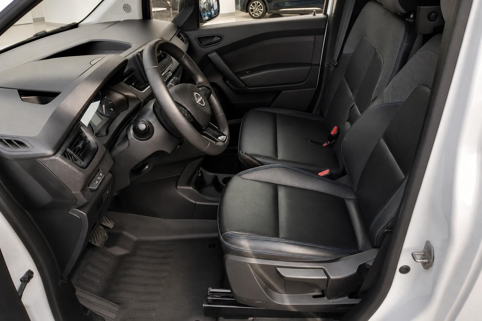 Nissan Townstar Innenraum mit schwarzen Sitzen und Lenkrad - Fahrersicht