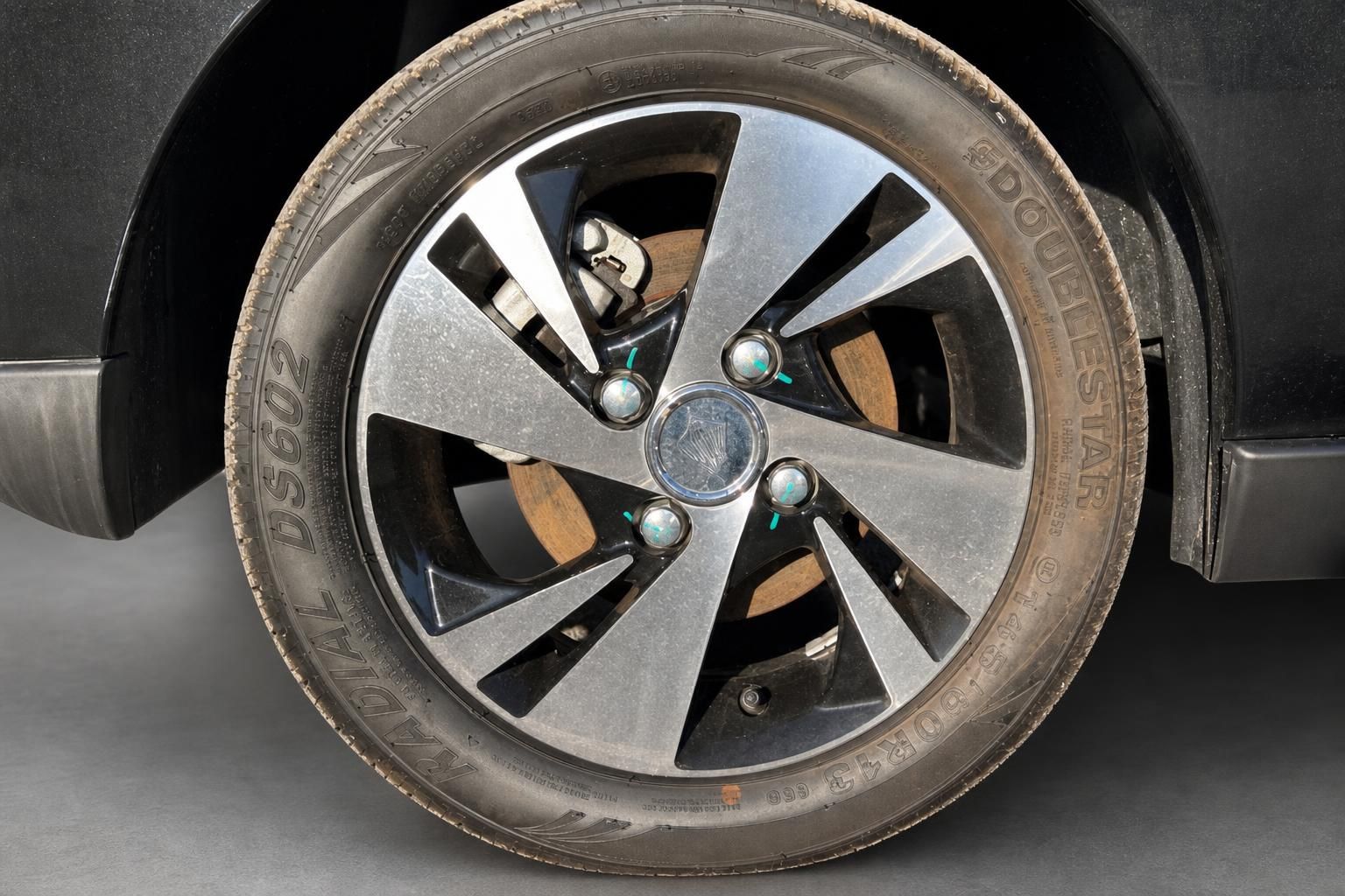Nahaufnahme Leichtmetallfelge mit Reifen an schwarzem Fahrzeug