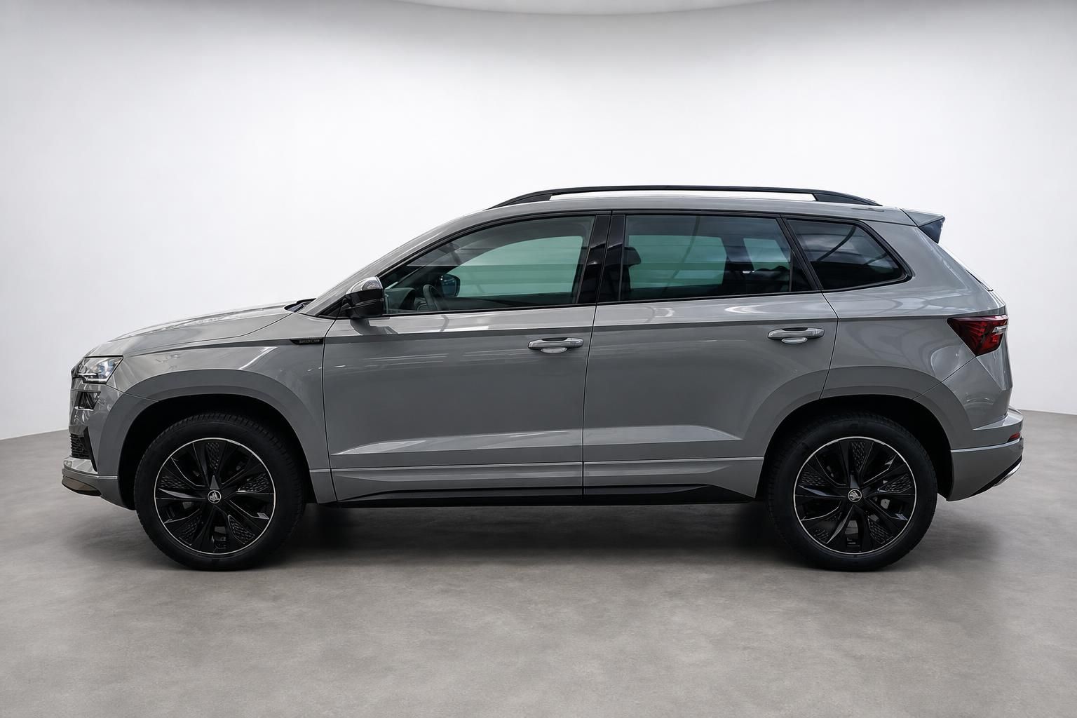 Skoda Karoq Seitenansicht grau mit schwarzen Felgen Studioaufnahme
