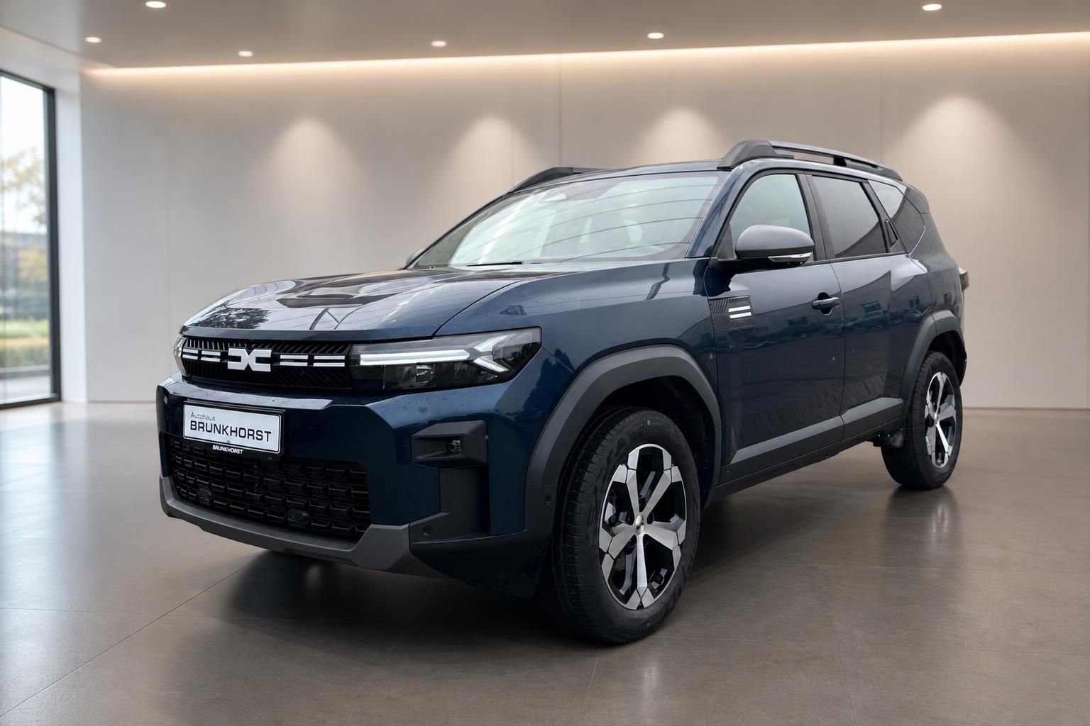 Dacia Bigster SUV in Blau - Dreiviertelansicht von vorne im modernen Autohaus-Showroom