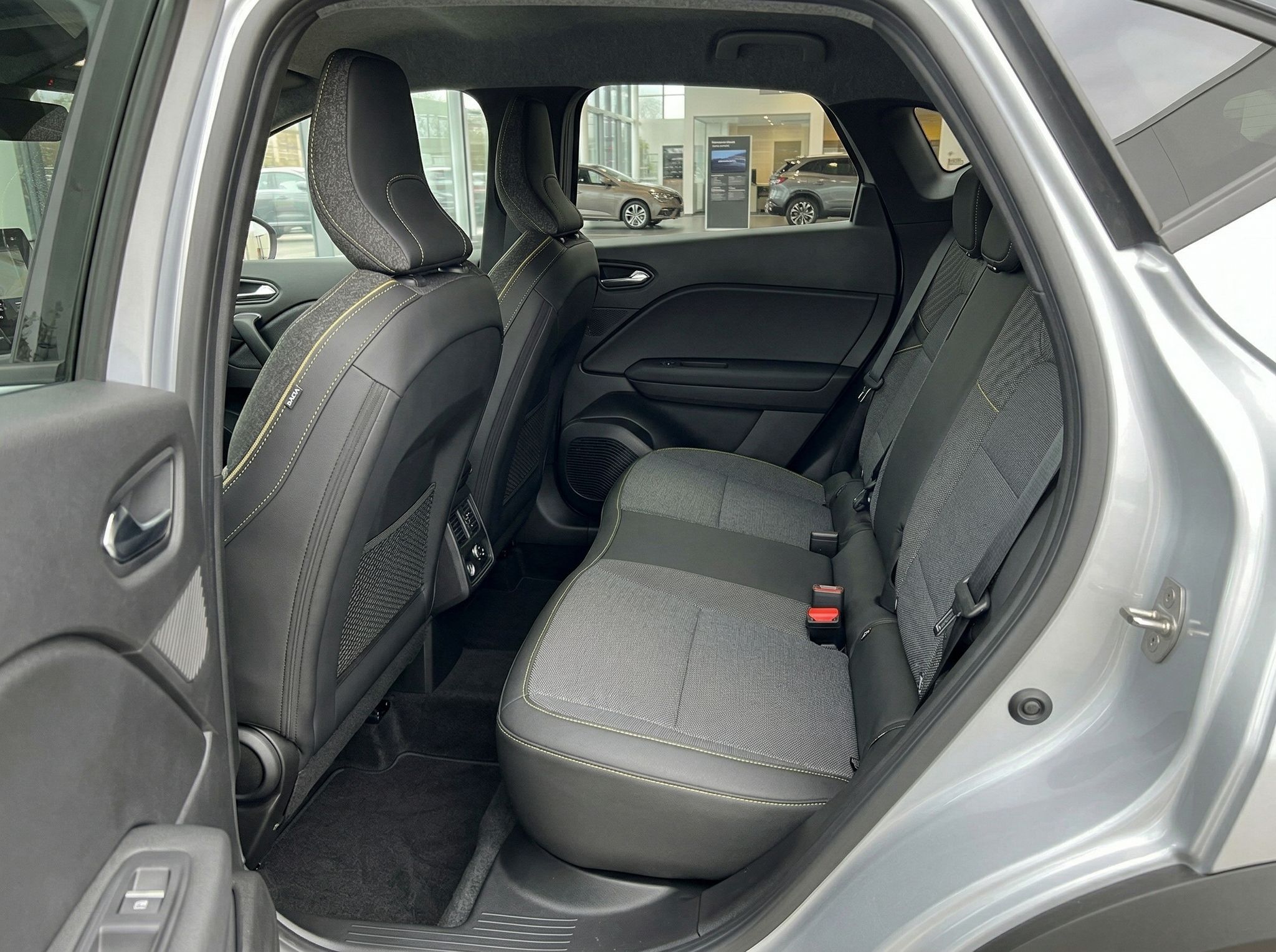 Renault Rücksitzbank mit grauen Stoffsitzen und Sicherheitsgurten in silbernem Fahrzeug