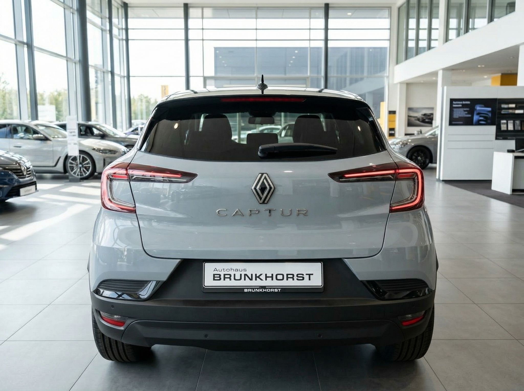 Renault Captur Heckansicht grau mit roten Rücklichtern im Autohaus