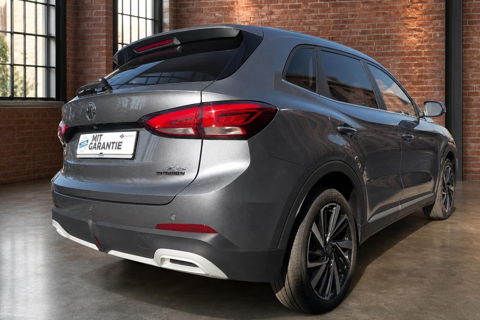MG ZS Hybrid+ Grau, Heck- und Seitenansicht im Showroom
