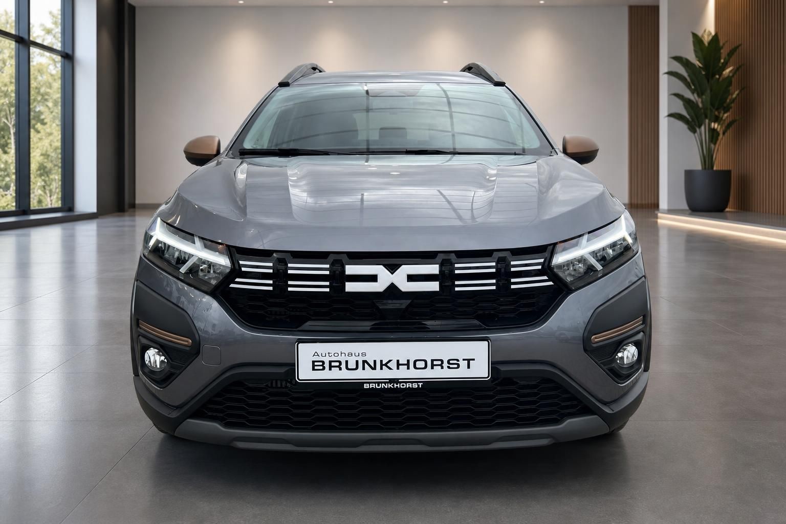 Dacia Jogger grau metallic Frontansicht mit markanter Kühlergrill im Autohaus