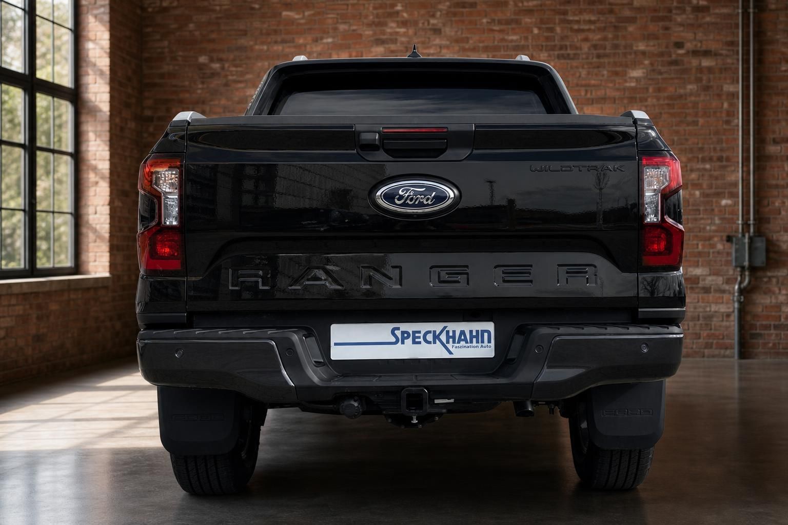 Ford Ranger Wildtrak schwarz Heckansicht in Industriehalle mit Backsteinwand