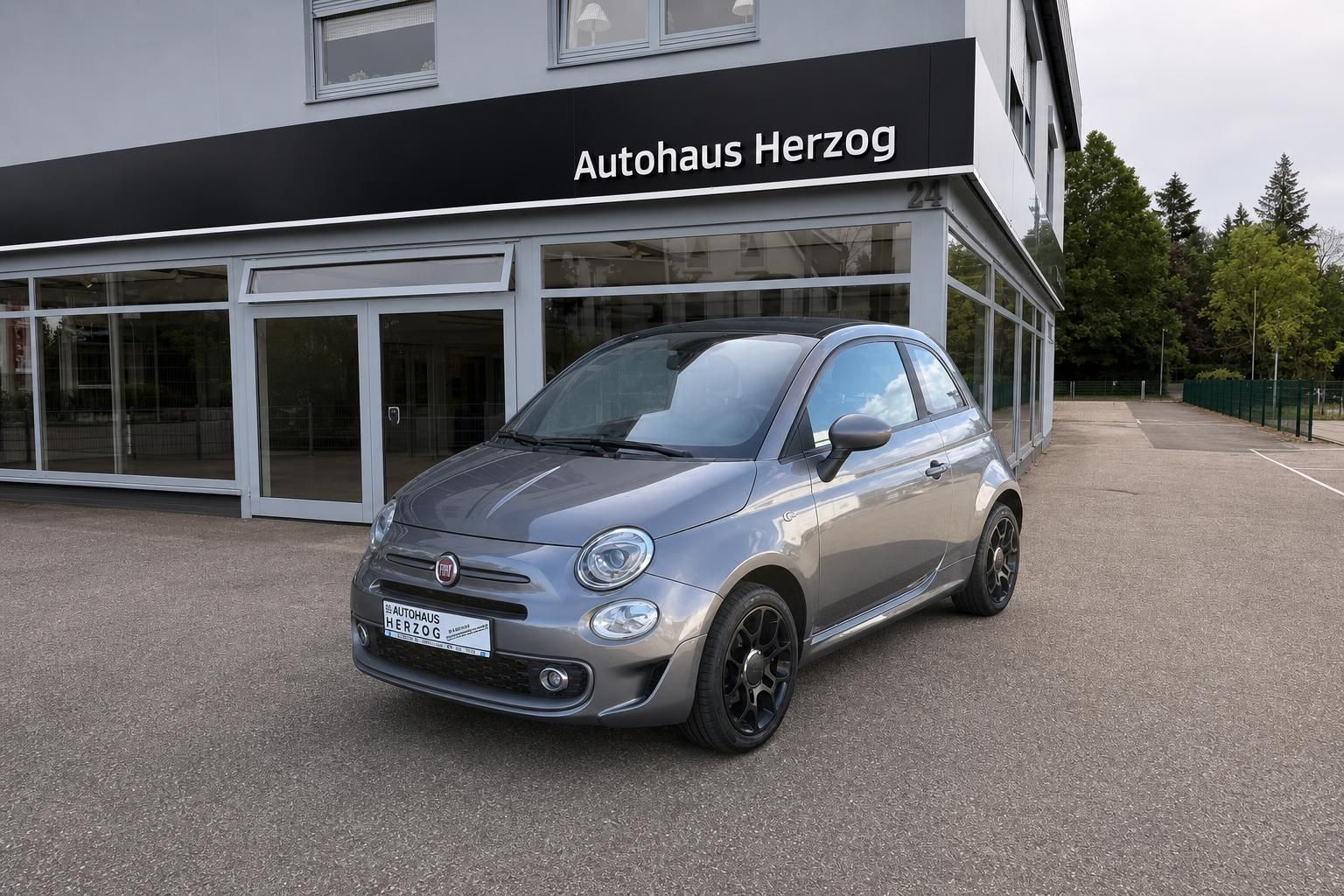 Fiat 500 grau Frontansicht mit schwarzen Felgen vor Autohaus